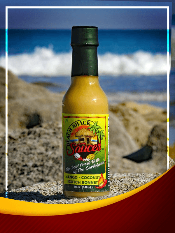 A bottle of Mango, Coconut & Scotch Bonnet Hot Sauce showcasing its vibrant color and tropical ingredients.