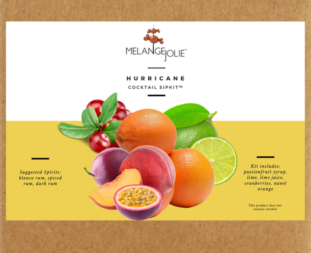 Mélange Jolie Hurricane Cocktail SipKit™ featuring a hurricane glass, bar tools, and homemade organic syrups with dehydrated fruits.