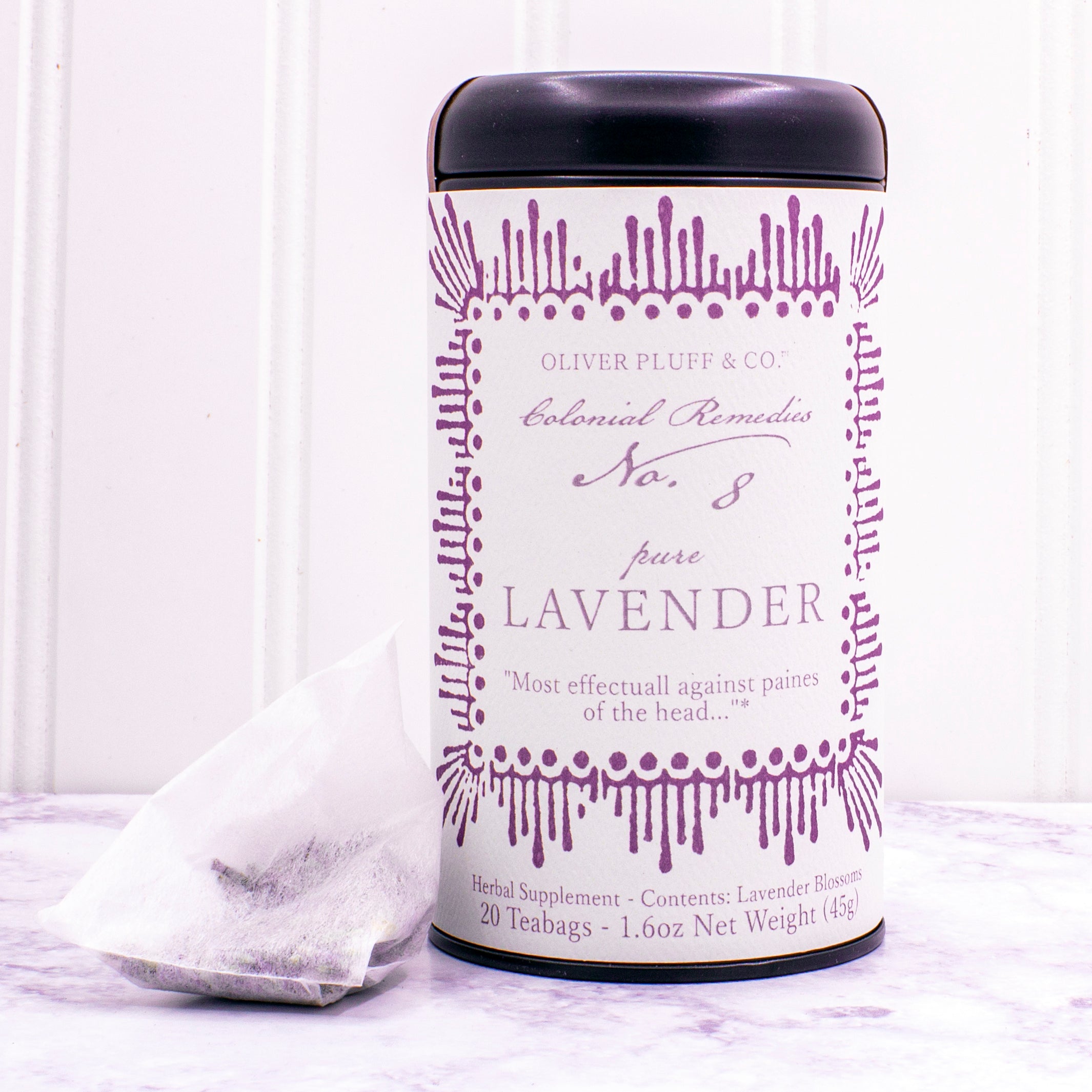 A matte black tin containing 20 biodegradable teabags of No. 8 Pure Lavender tea, showcasing lavender blossoms.