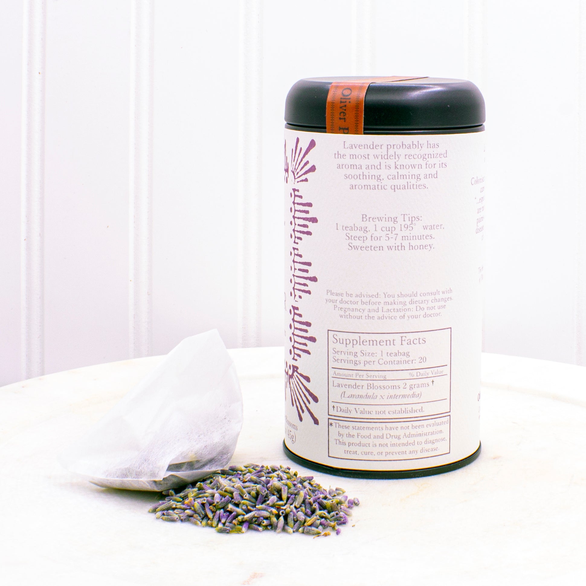 A matte black tin containing 20 biodegradable teabags of No. 8 Pure Lavender tea, showcasing lavender blossoms.