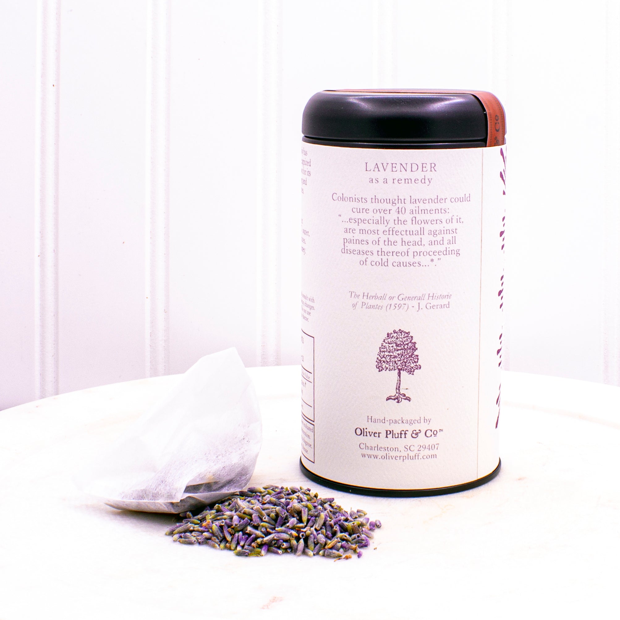 A matte black tin containing 20 biodegradable teabags of No. 8 Pure Lavender tea, showcasing lavender blossoms.