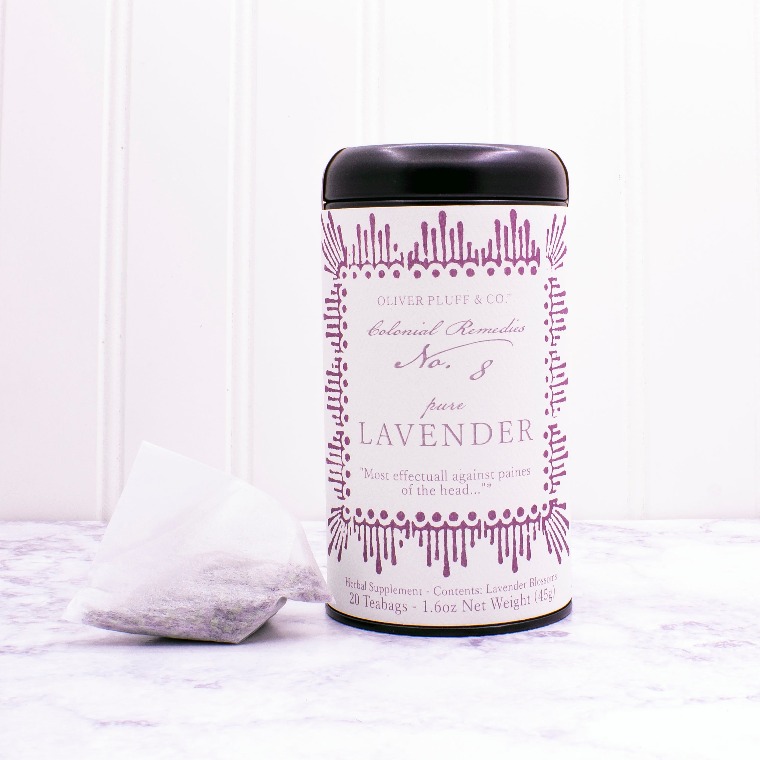 A matte black tin containing 20 biodegradable teabags of No. 8 Pure Lavender tea, showcasing lavender blossoms.