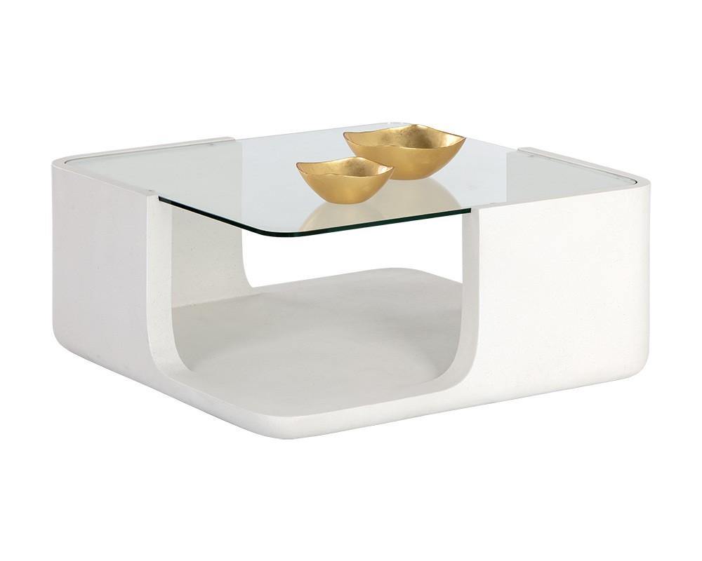 Odis Coffee Table featuring a white concrete base and clear glass top, showcasing its modern design and unique texture.