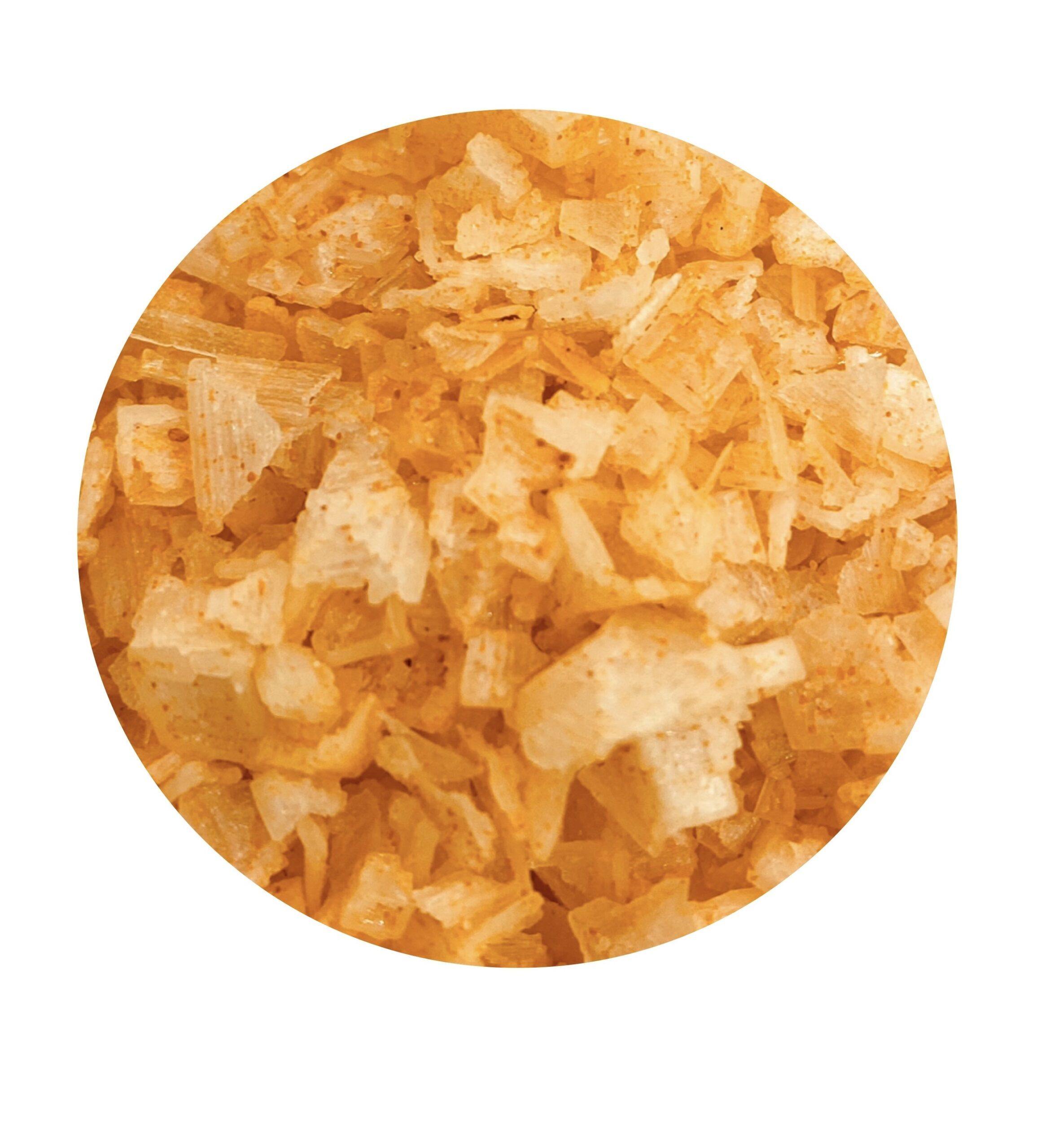 A close-up of ORANGE salt flakes ecopack, showcasing the vibrant orange color and crunchy texture of the gourmet seasoning.