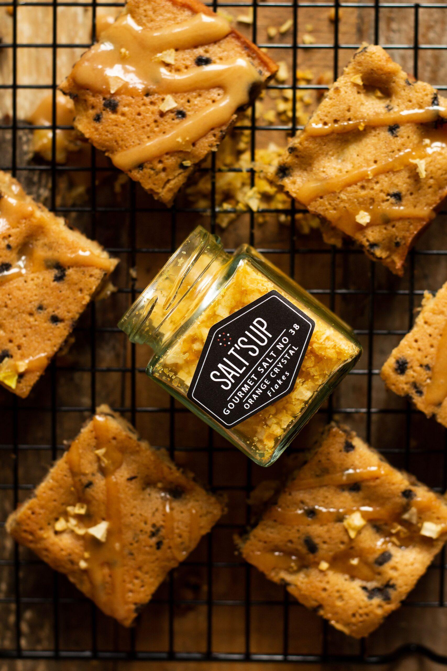 A close-up of ORANGE salt flakes ecopack, showcasing the vibrant orange color and crunchy texture of the gourmet seasoning.