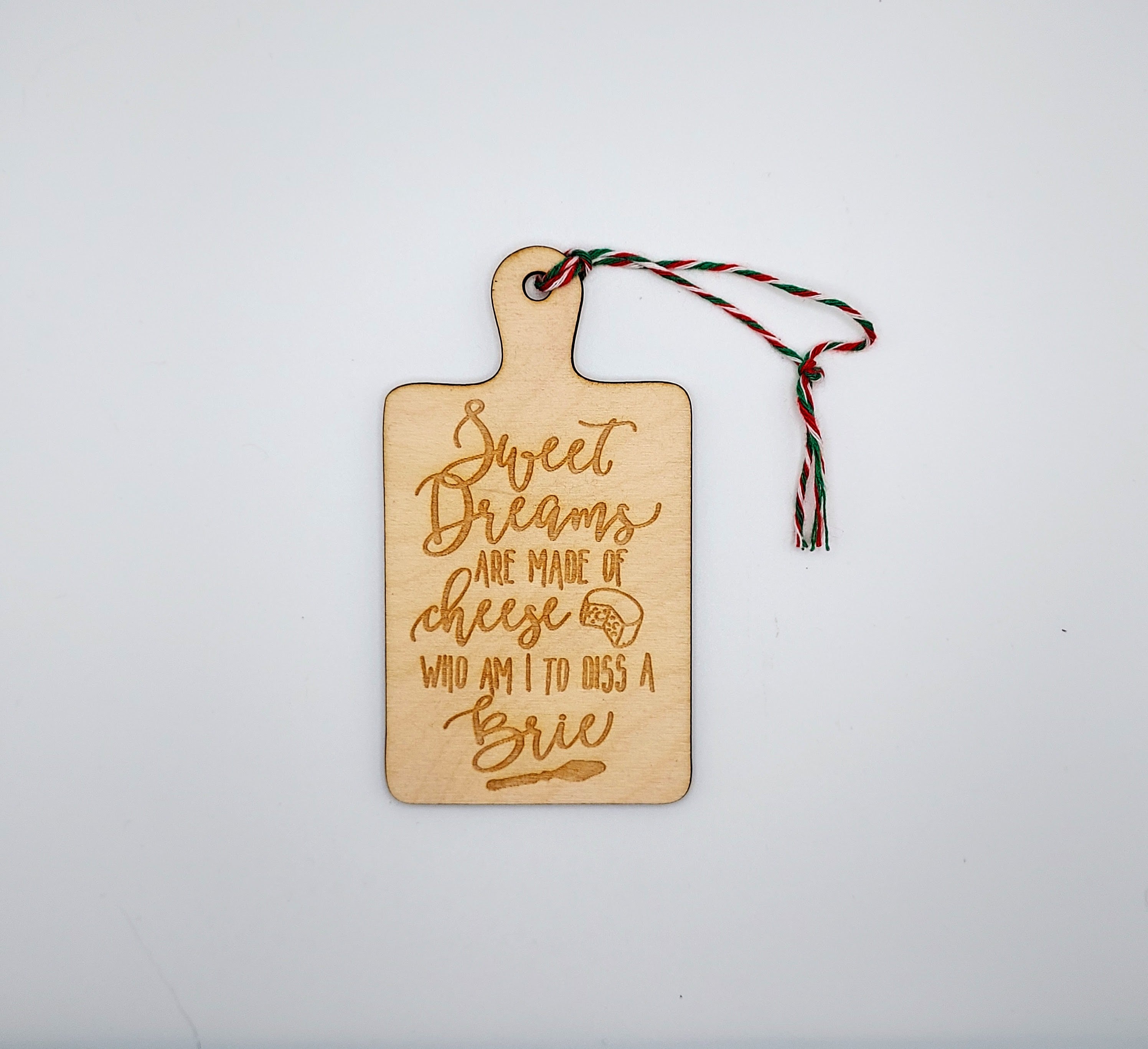 A charming wooden ornament featuring whimsical cheese-themed quotes, perfect for home decor.