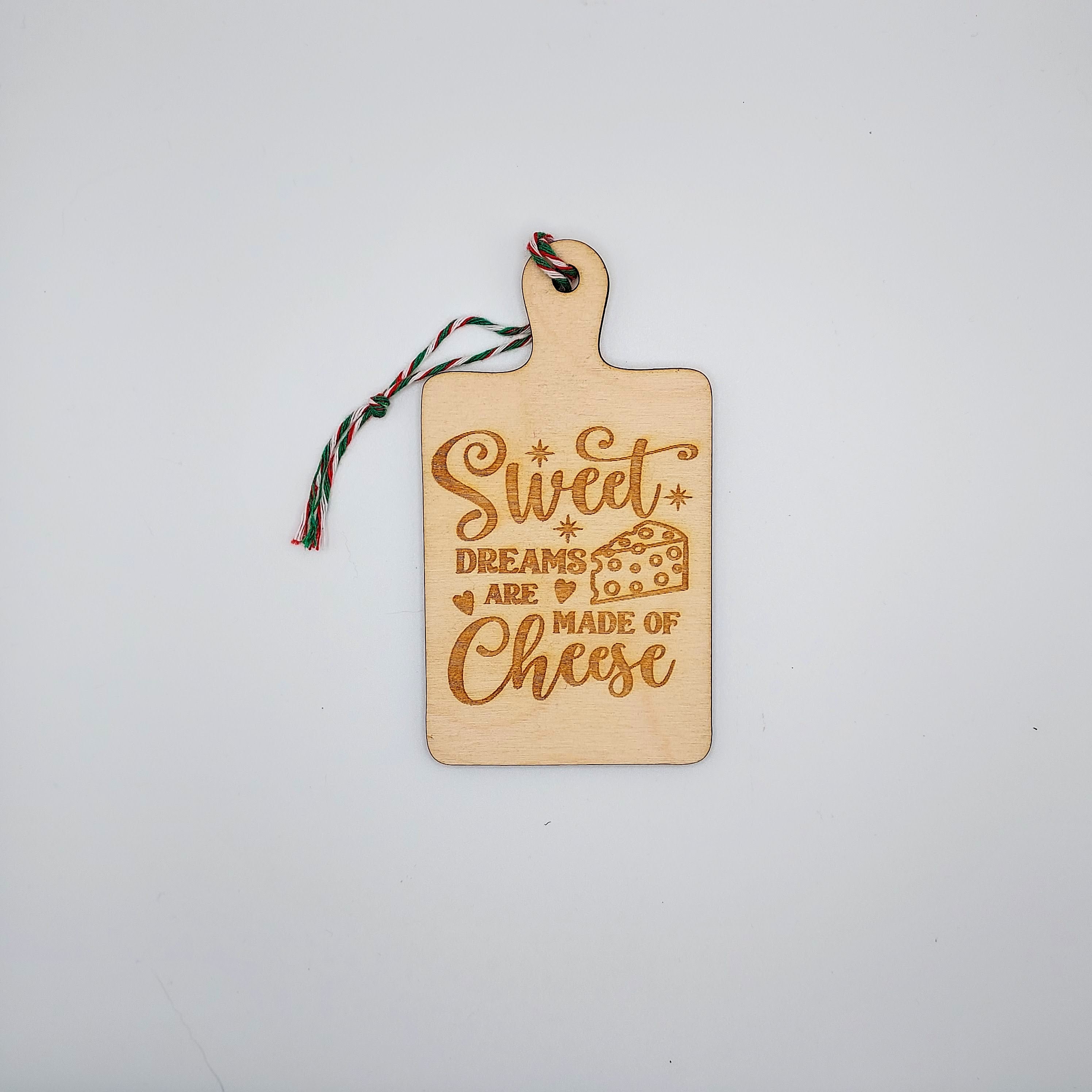 A charming wooden ornament featuring whimsical cheese-themed quotes, perfect for home decor.