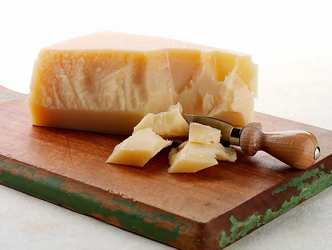 A block of aged Parmesan cheese with a granular texture, showcasing its rich, buttery color and perfect for grating or shaving.