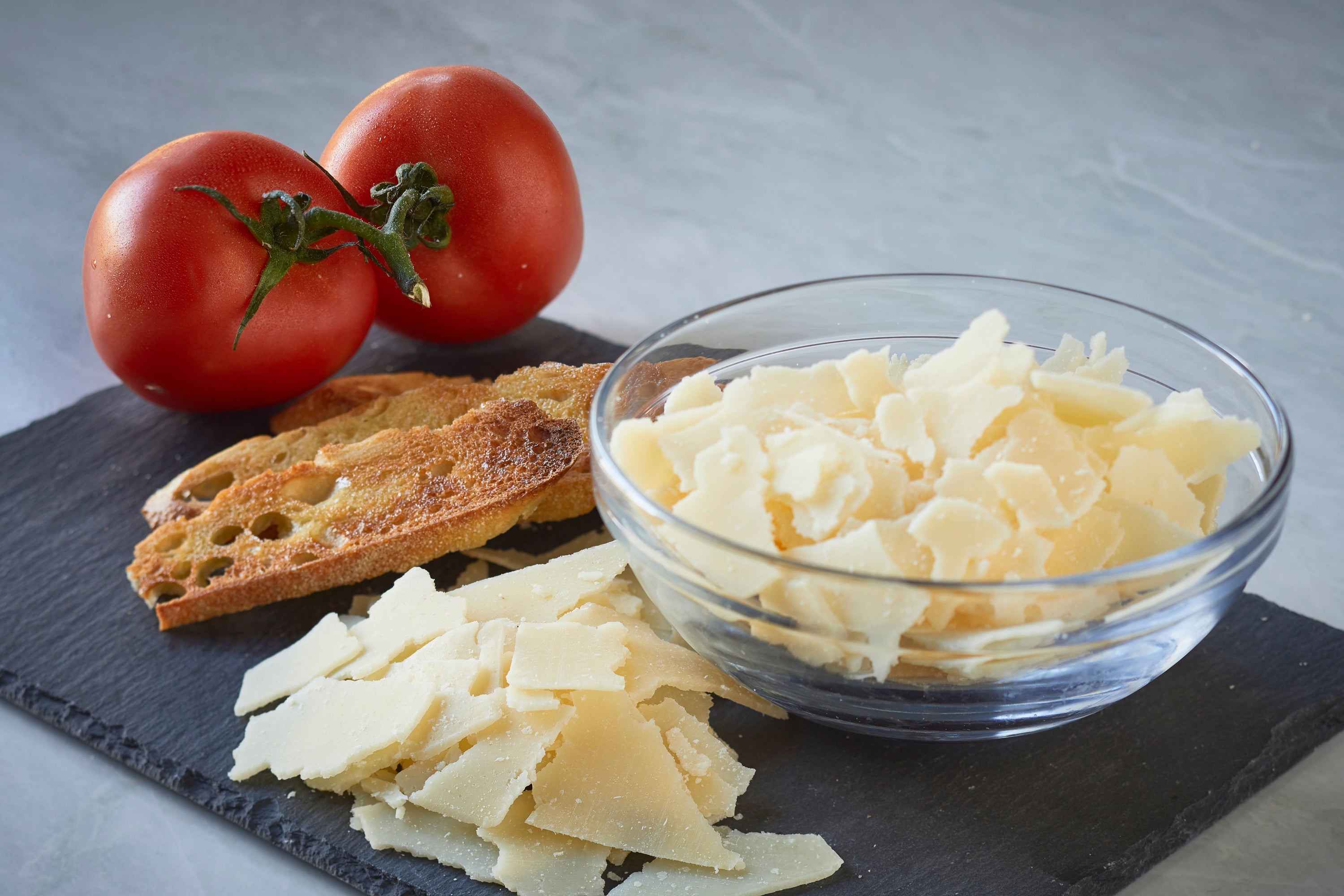 A block of aged Parmesan cheese with a granular texture, showcasing its rich, buttery color and perfect for grating or shaving.