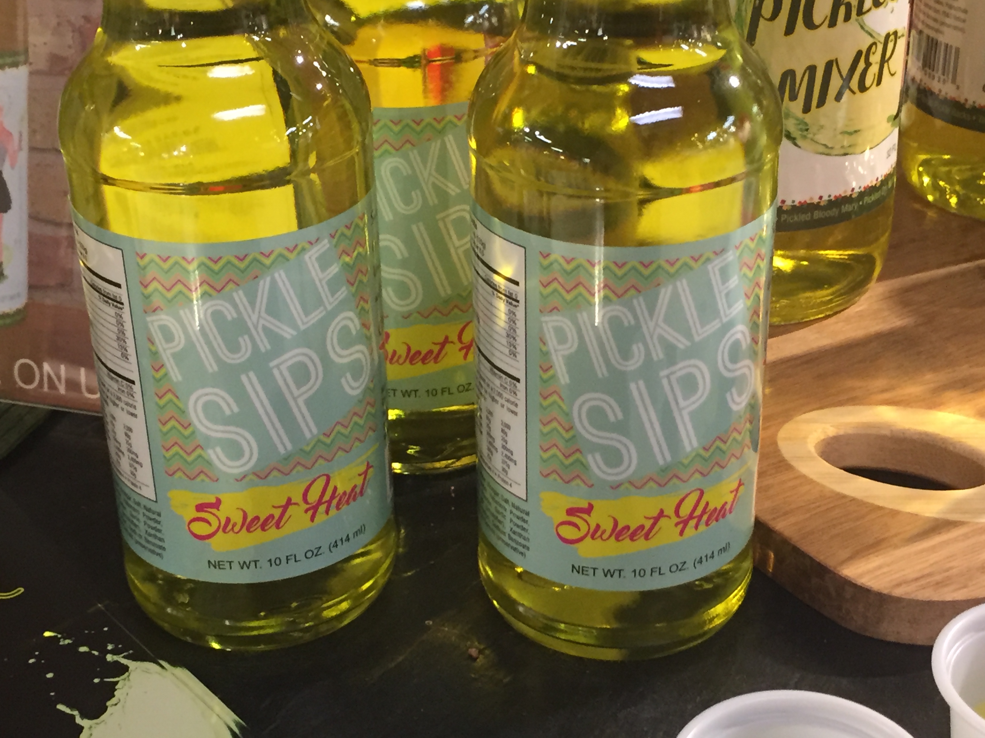 A 10 oz bottle of PICKLE SIPS™ - SWEET HEAT featuring sweet pickle juice with habanero spice, ideal for hydration.