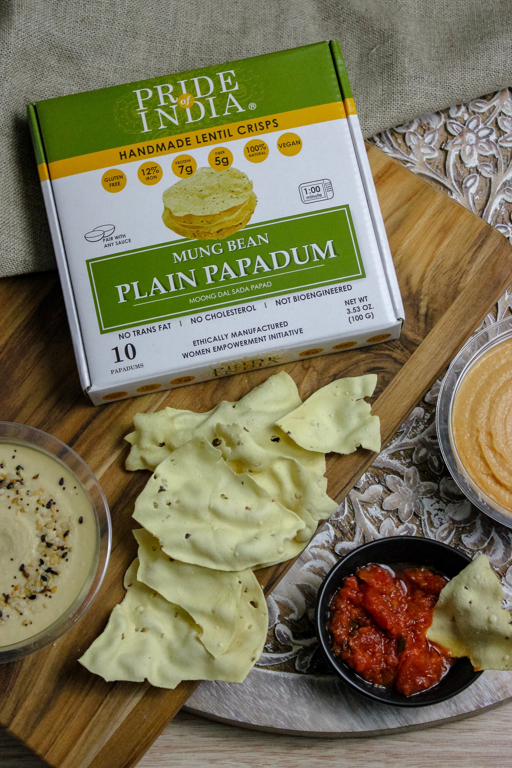 A pack of Plain Mung Bean Sada Papadum, showcasing the lentil crisps with a rustic background, highlighting their handmade quality.