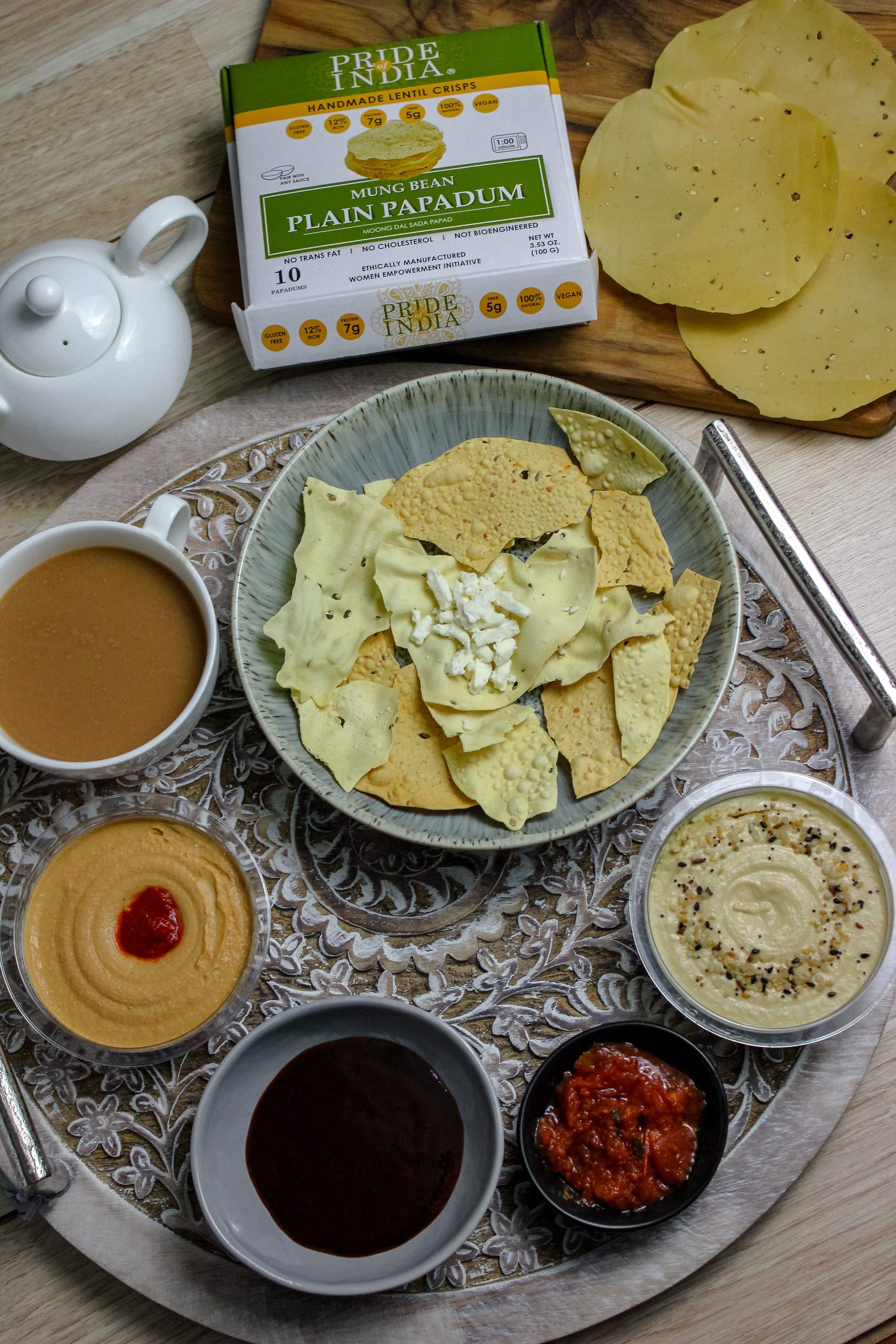 A pack of Plain Mung Bean Sada Papadum, showcasing the lentil crisps with a rustic background, highlighting their handmade quality.