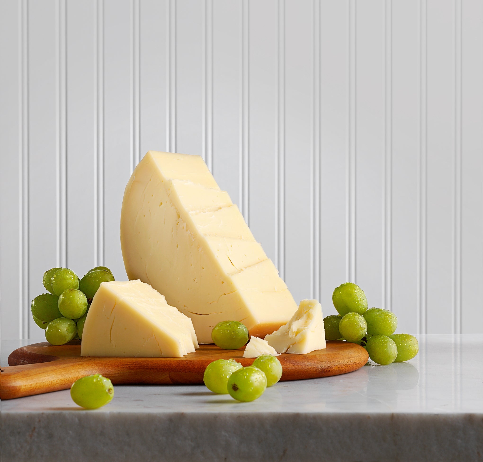 A block of Provolone cheese, showcasing its firm texture and rich color, perfect for slicing or shredding.