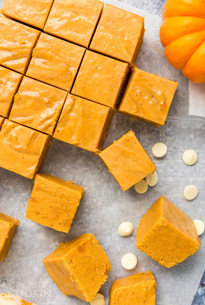 A block of Pumpkin Spice Cheddar cheese infused with autumn spices, showcasing its creamy texture and warm orange hue.