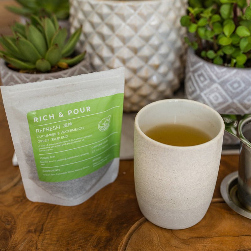 A vibrant cup of cucumber and watermelon green tea blend, showcasing fresh cucumber slices and watermelon accents.