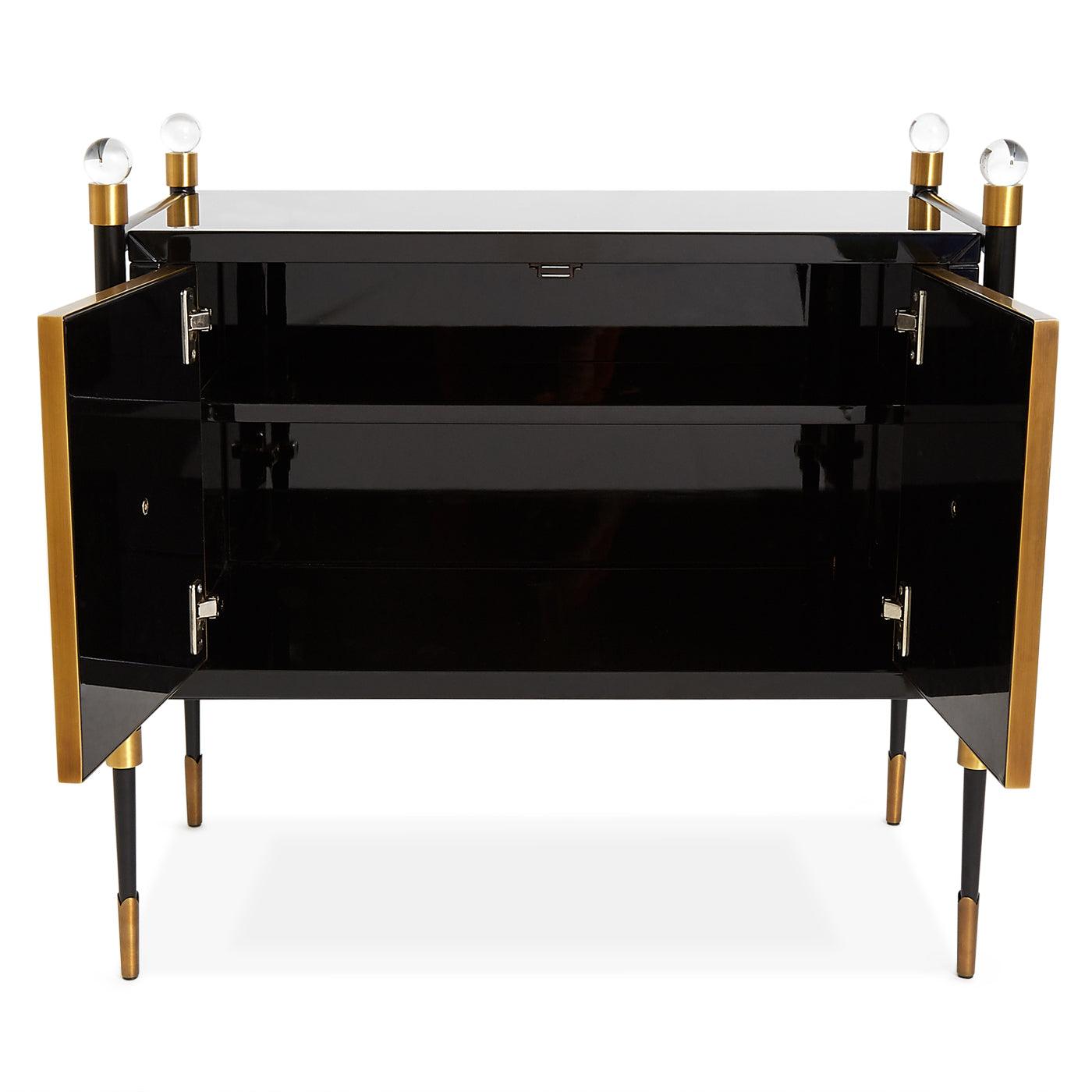 Rider Small Cabinet by Jonathan Adler featuring glossy black lacquer, antiqued brass accents, and acrylic finials, showcasing modern elegance.