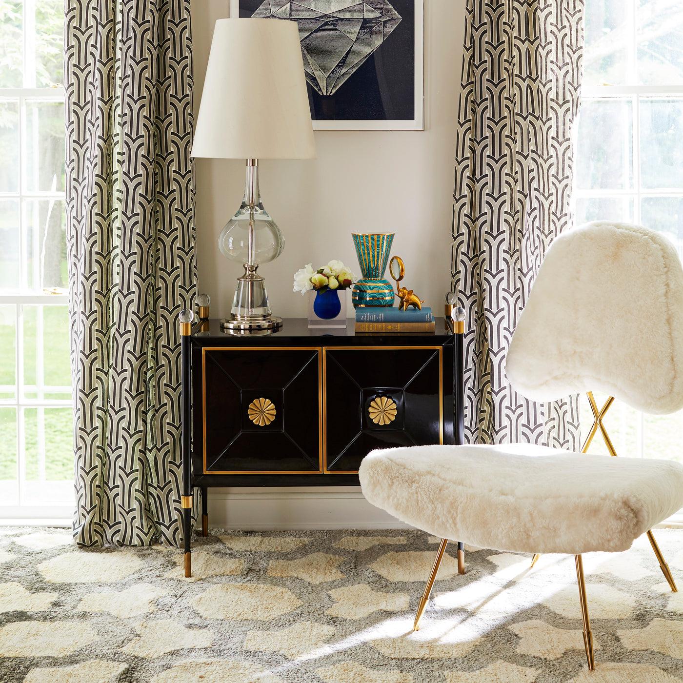 Rider Small Cabinet by Jonathan Adler featuring glossy black lacquer, antiqued brass accents, and acrylic finials, showcasing modern elegance.