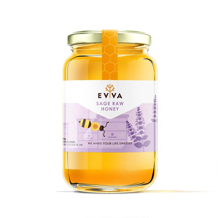 A jar of EVVA Sage Raw Honey showcasing its rich golden color and natural texture, surrounded by honeycomb and flowers.