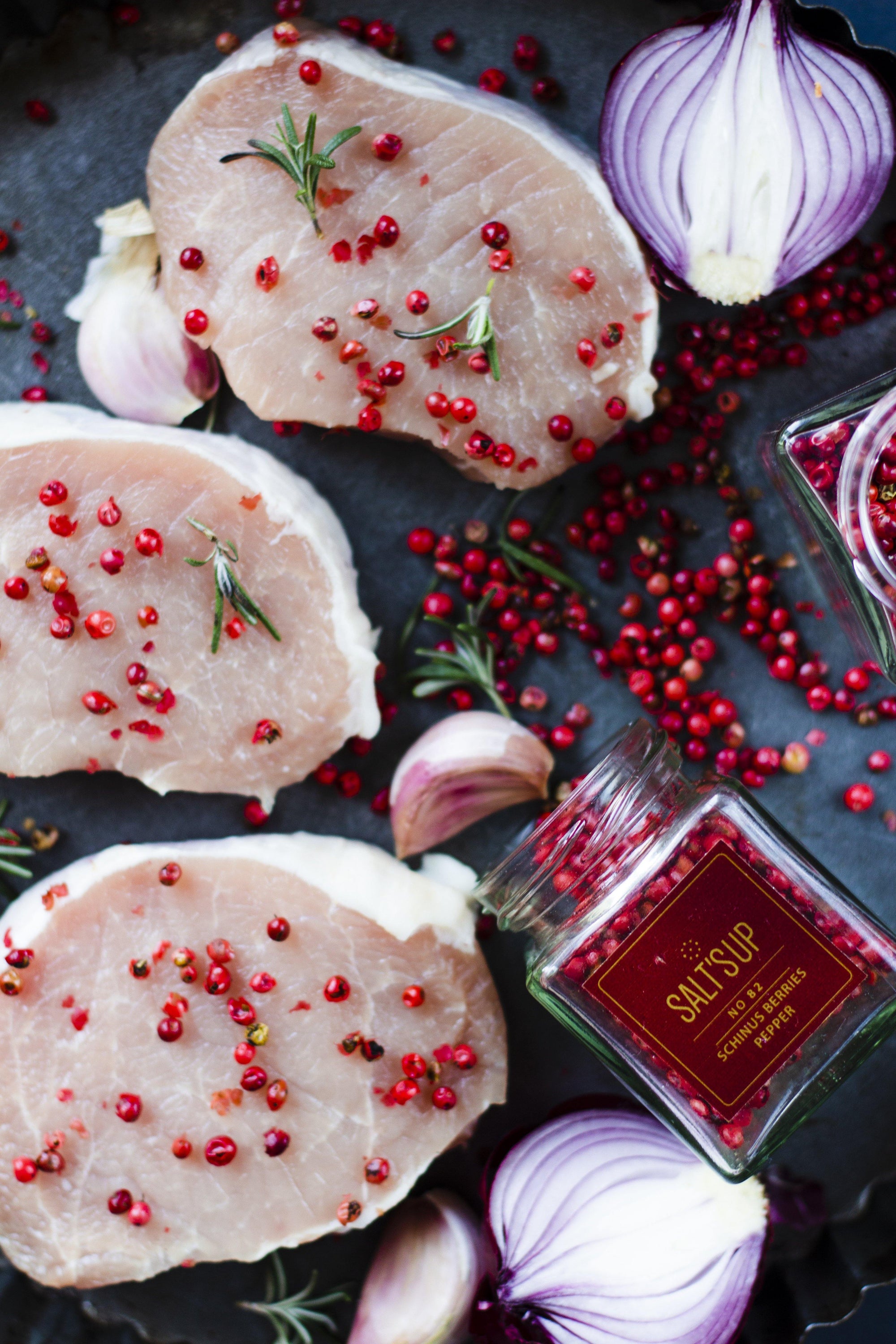 A glass jar containing SCHINUSBERRIES pepper, showcasing its vibrant pink berries, perfect for culinary use.