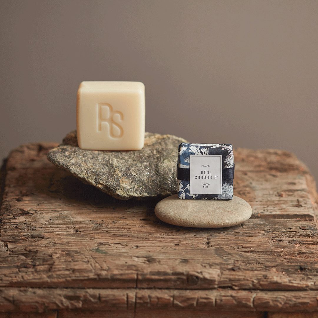 A bar of Seaweed Soap with olive oil, showcasing its natural green color and texture, placed on a wooden surface with seaweed accents.