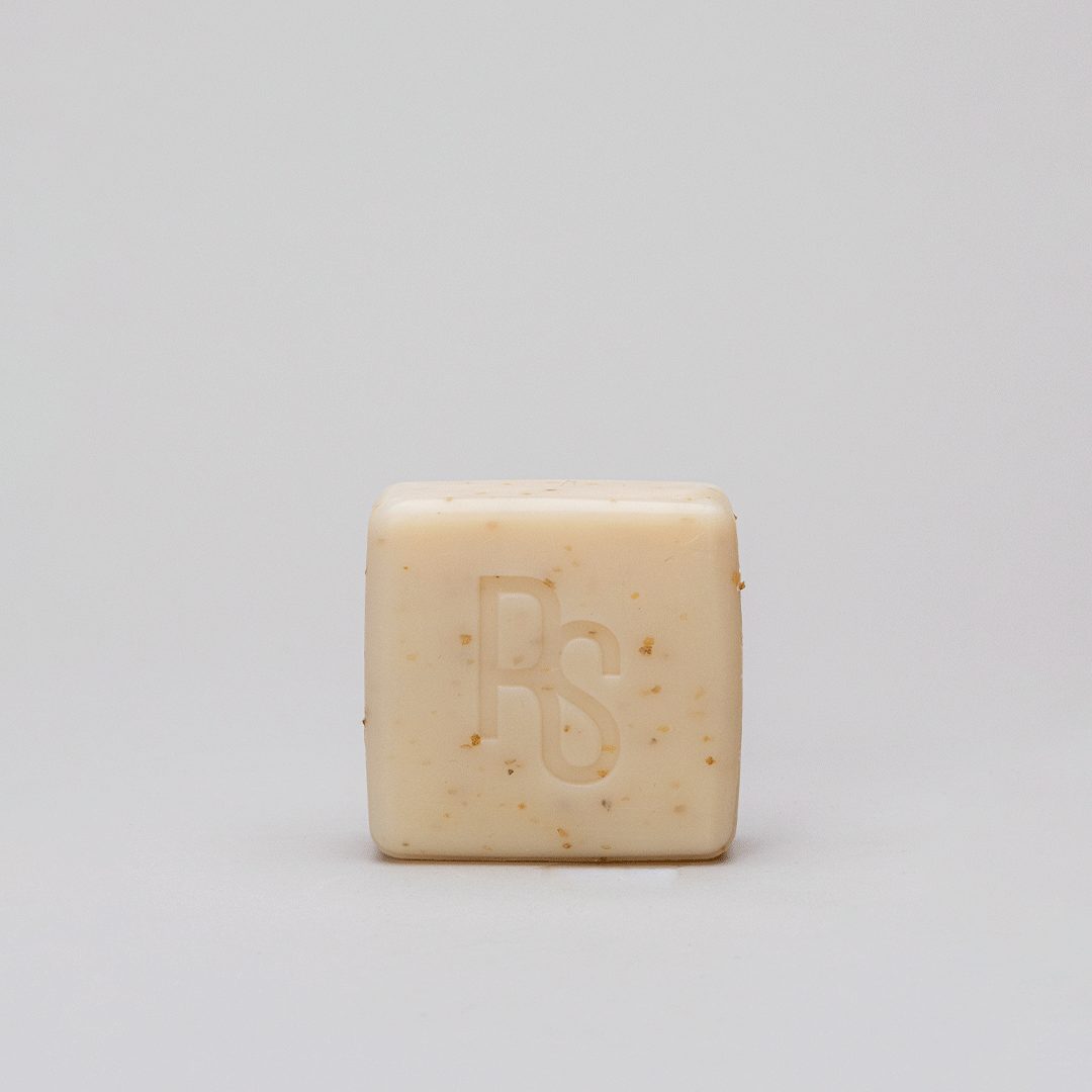 A bar of Seaweed Soap with olive oil, showcasing its natural green color and texture, placed on a wooden surface with seaweed accents.