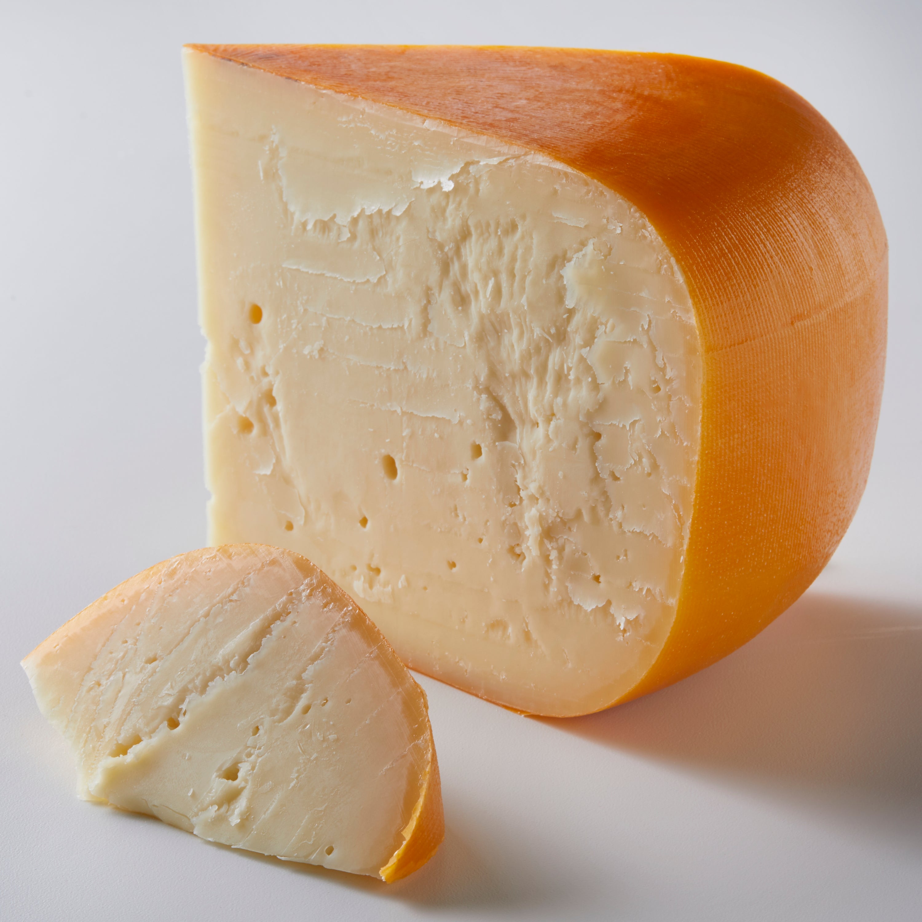 A block of Smoked Gouda cheese with a rich, smoky flavor, perfect for cheese boards and recipes.