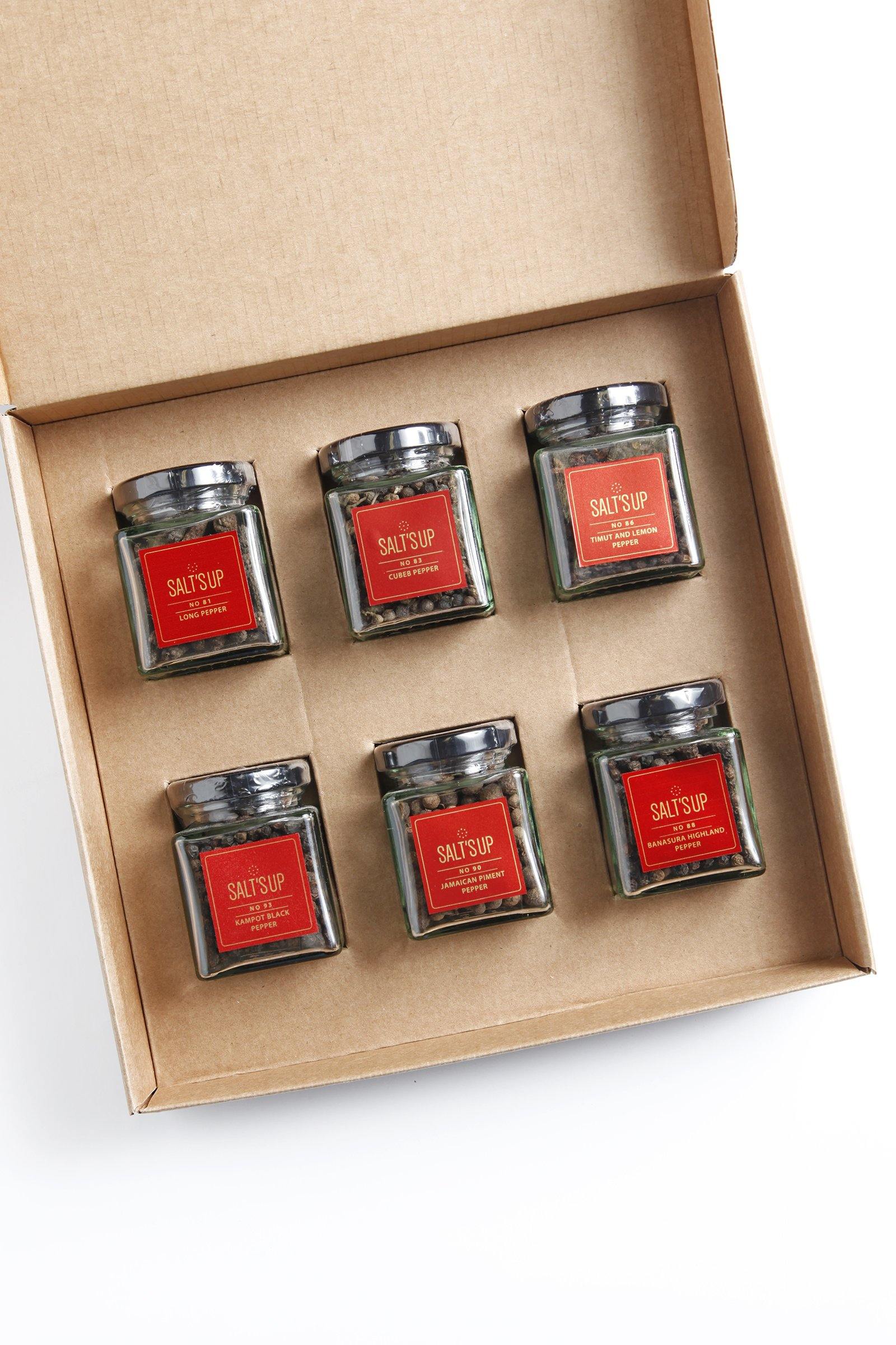 A beautifully arranged starter set of gourmet peppers in glass jars, showcasing various colors and textures, perfect for culinary enthusiasts.