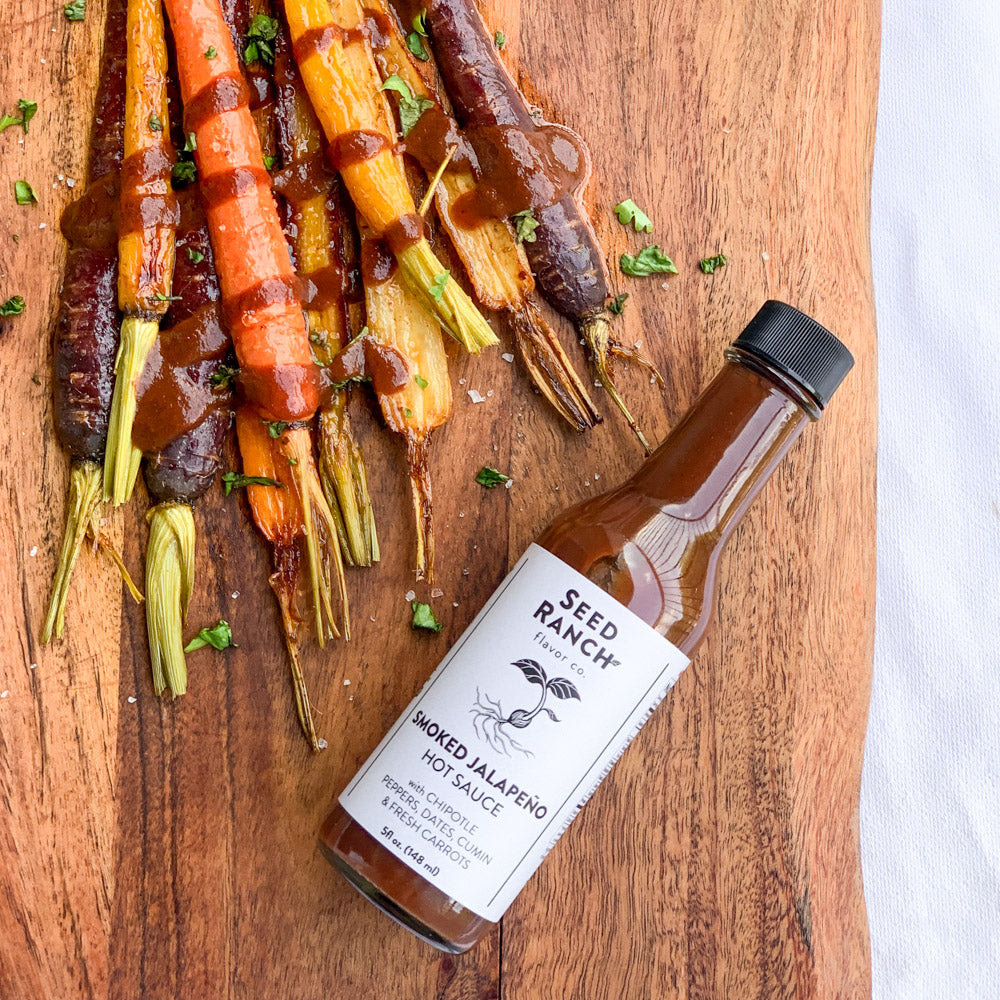 A collection of four unique sauces from Seed Ranch Flavor Co., showcasing Umami Everyday Sauce, Smoked Jalapeño, Thai Green, and Umami Reserve.