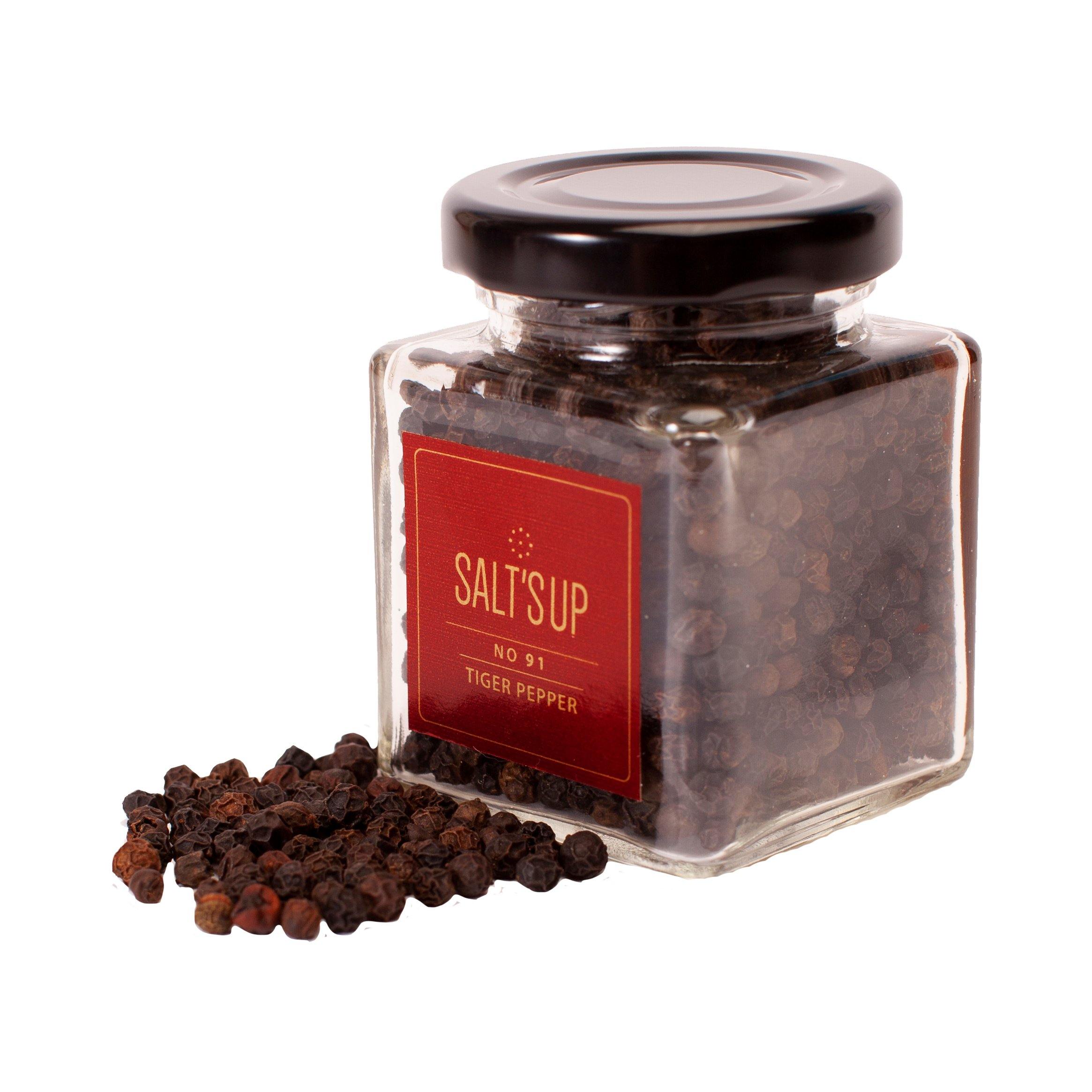 A glass jar of TIGER Pepper, also known as Malabar black pepper, showcasing its rich, dark peppercorns sourced from Kerala, India.