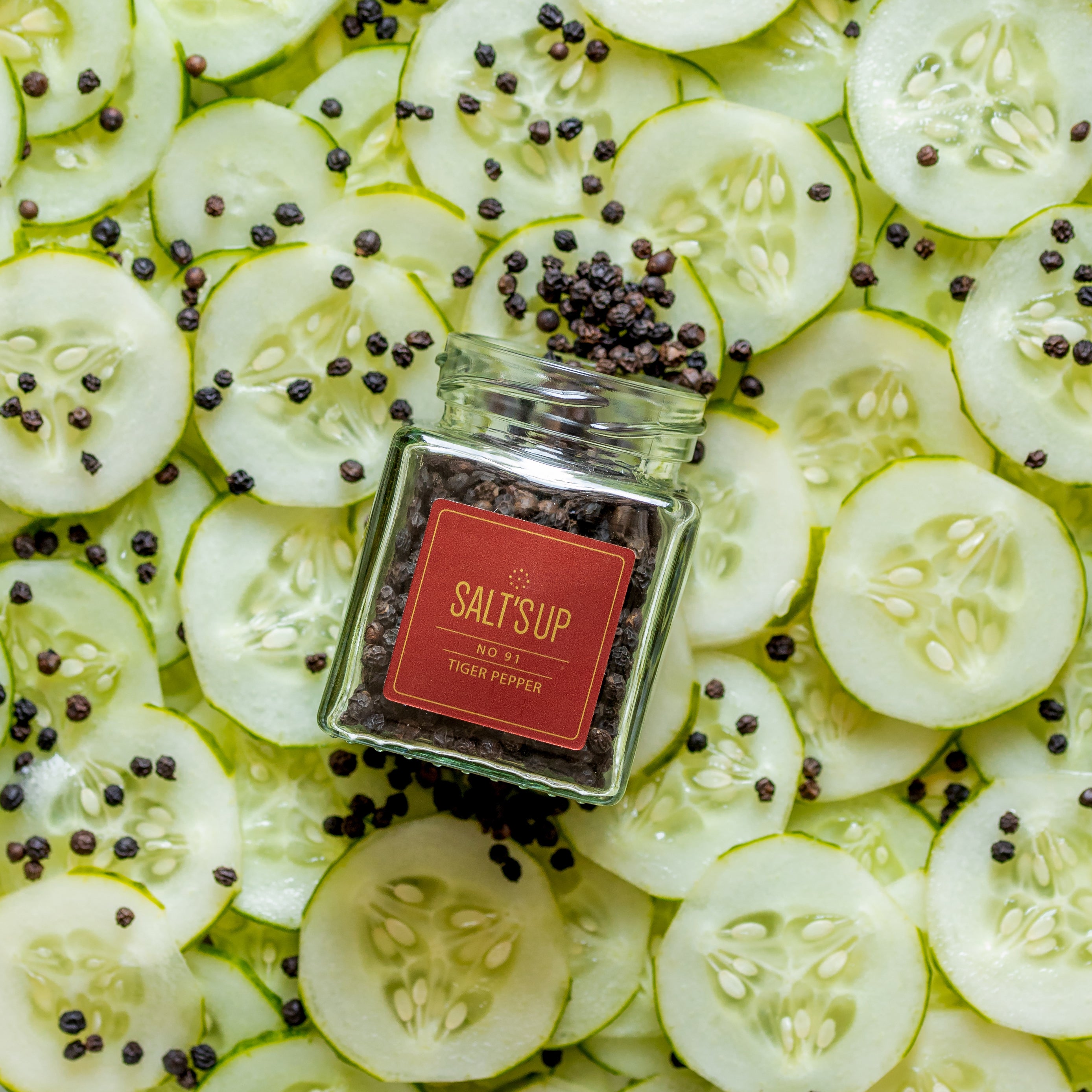 A glass jar of TIGER Pepper, also known as Malabar black pepper, showcasing its rich, dark peppercorns sourced from Kerala, India.