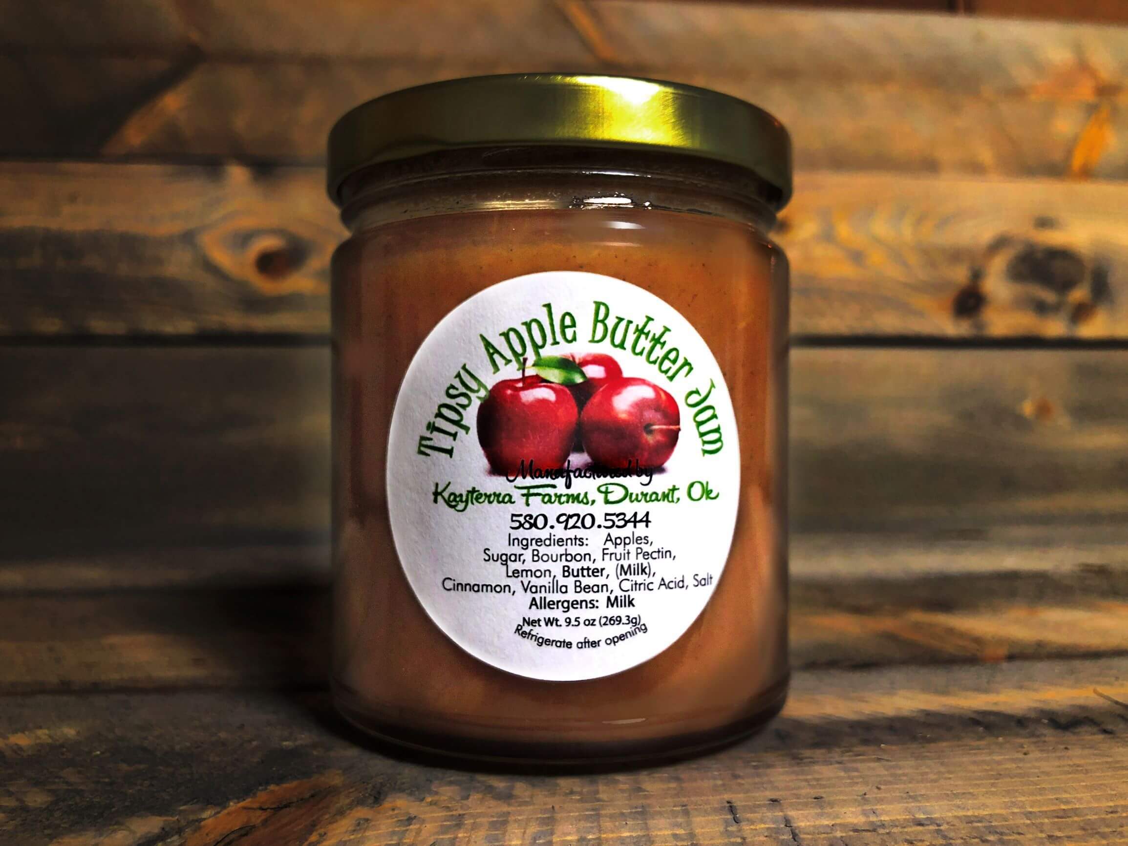 A jar of Tipsy Apple Butter Jam showcasing its rich, golden-brown color, with a hint of cinnamon and bourbon flavor.