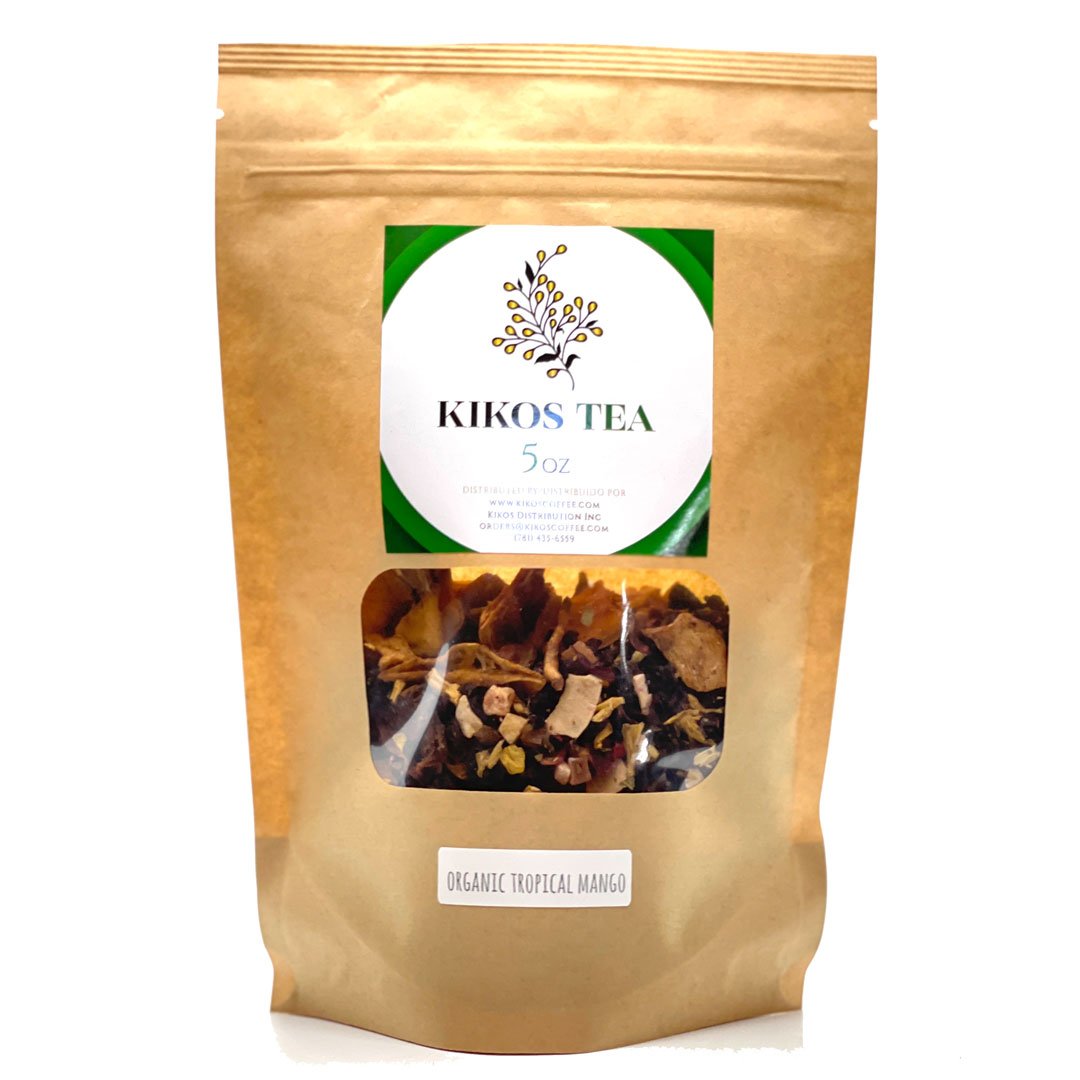 A vibrant package of Tisane Tropical Mango Tea featuring tropical fruits like mango, papaya, and coconut, with loose-leaf tea visible.