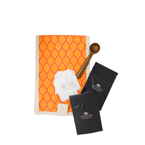 Traveler's Tea Gift Kit featuring artisanal wooden spoon, premium loose leaf teas, and organic cotton pouch, perfect for tea lovers on the go.