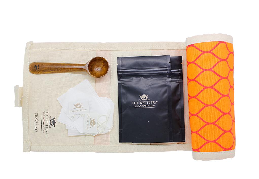 Traveler's Tea Gift Kit featuring artisanal wooden spoon, premium loose leaf teas, and organic cotton pouch, perfect for tea lovers on the go.