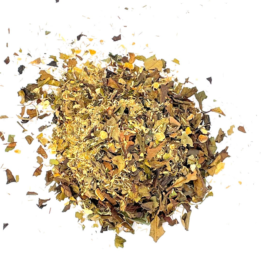 A vibrant cup of White Lychee Ginger Lime Tea with loose leaf tea ingredients displayed around it, showcasing ginger, lemongrass, and citrus fruits.