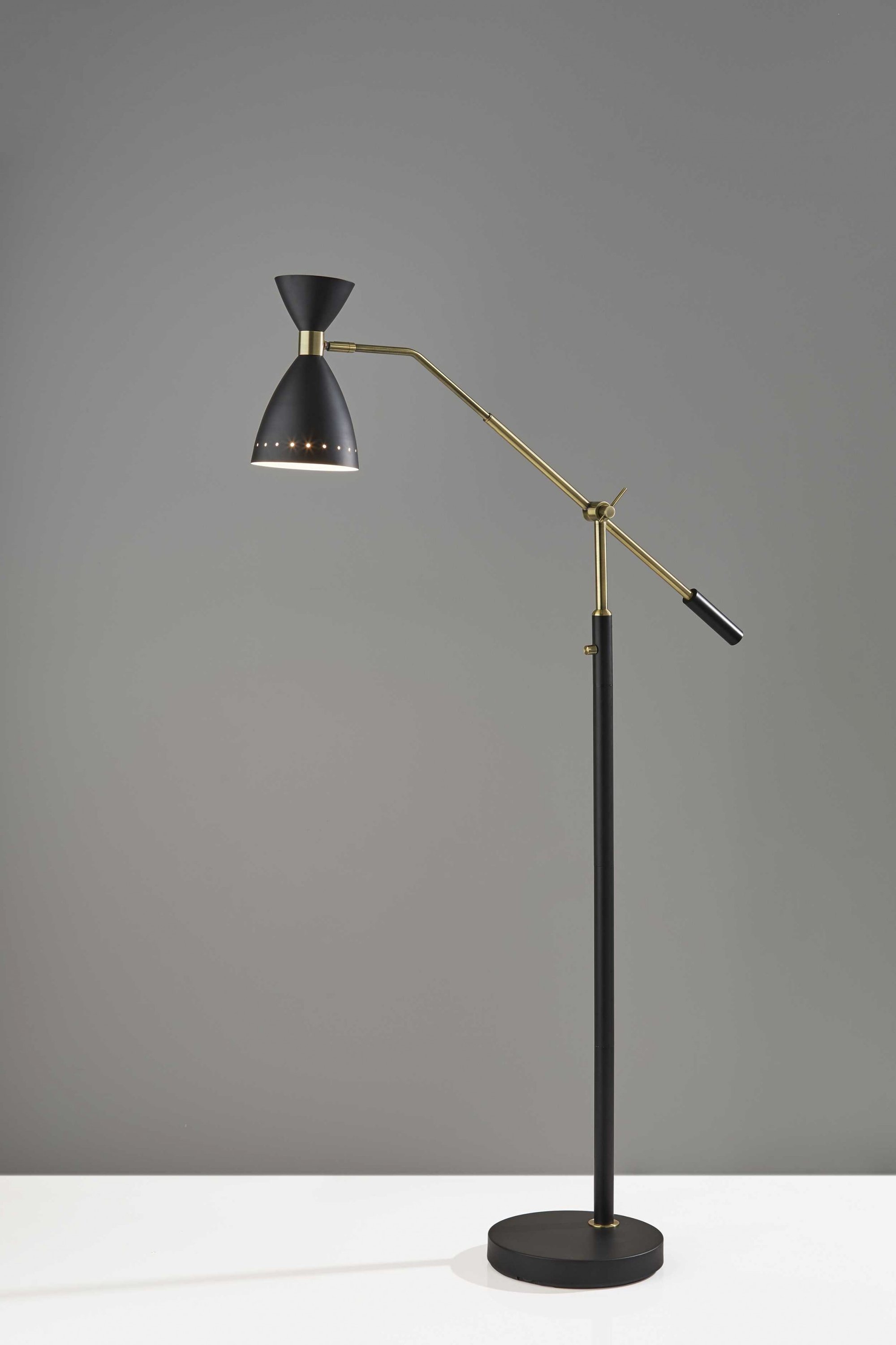 A stylish black metal adjustable floor lamp with an oversized shade and antique brass accents, perfect for modern decor.