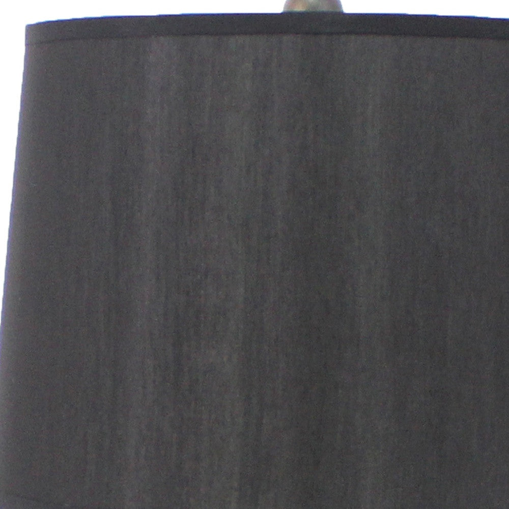 A traditional wooden table lamp featuring a black linen shade, elegantly designed to enhance home decor.