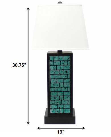 A contemporary teal brick pattern table lamp with a white linen shade, showcasing a stylish metal base.