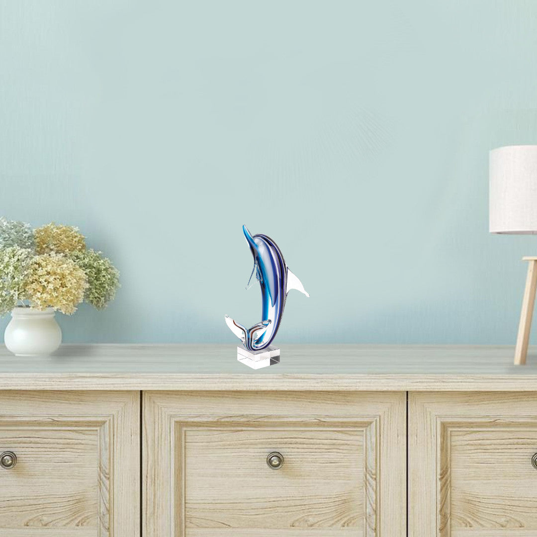 A stunning 14-inch tall mouth blown blue dolphin art glass on a clear base, showcasing vibrant colors and elegant design.