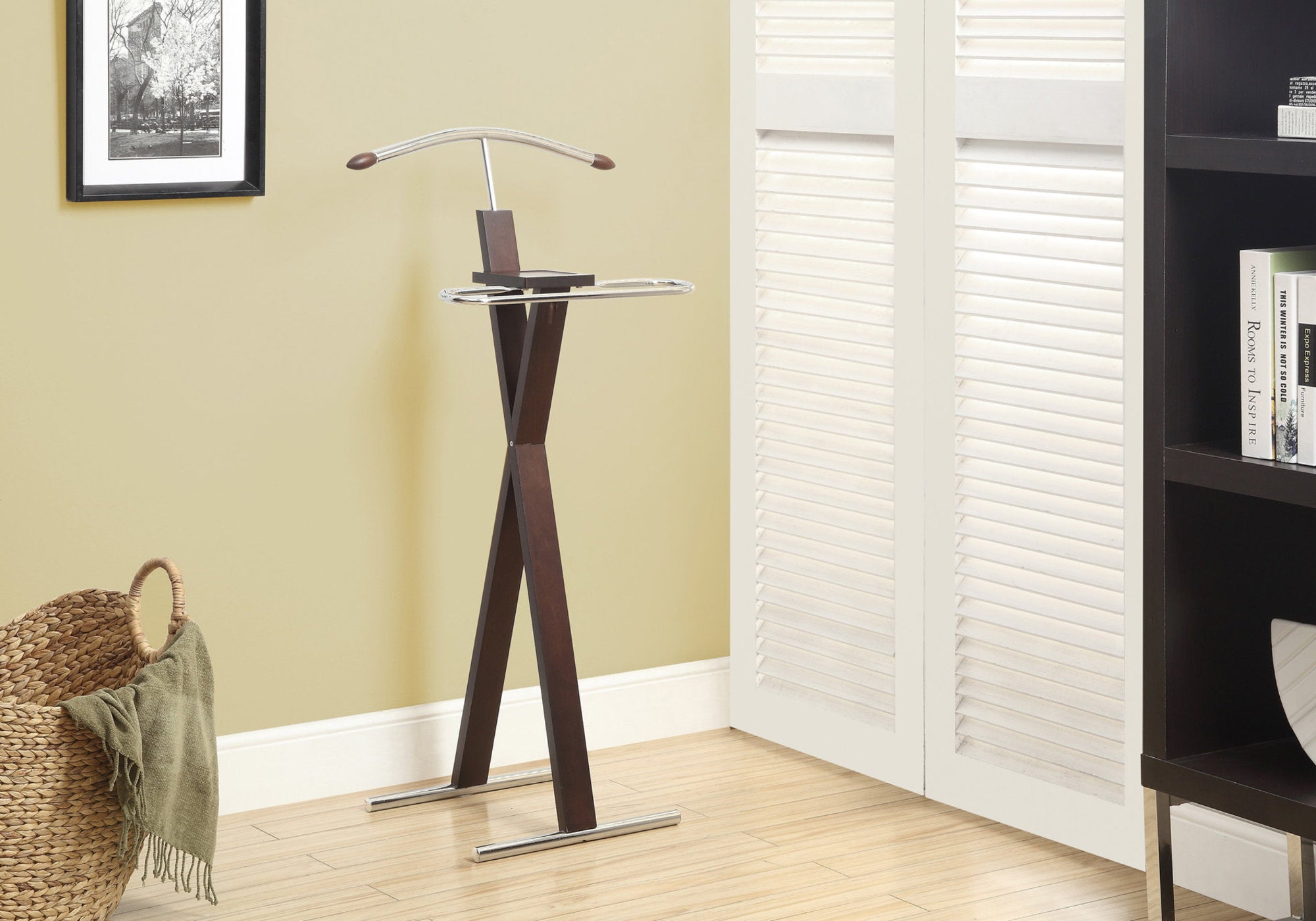 Cappuccino solid wood valet stand with chrome accents, featuring a hanger, accessory tray, and trouser bar, elegantly displayed in a dressing room.