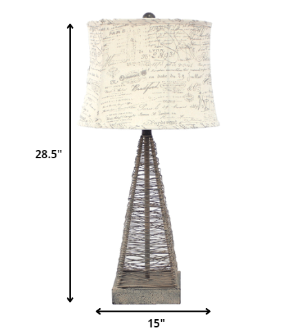 Tan industrial metal table lamp with a cone wire mesh base and round white linen shade, perfect for home decor.