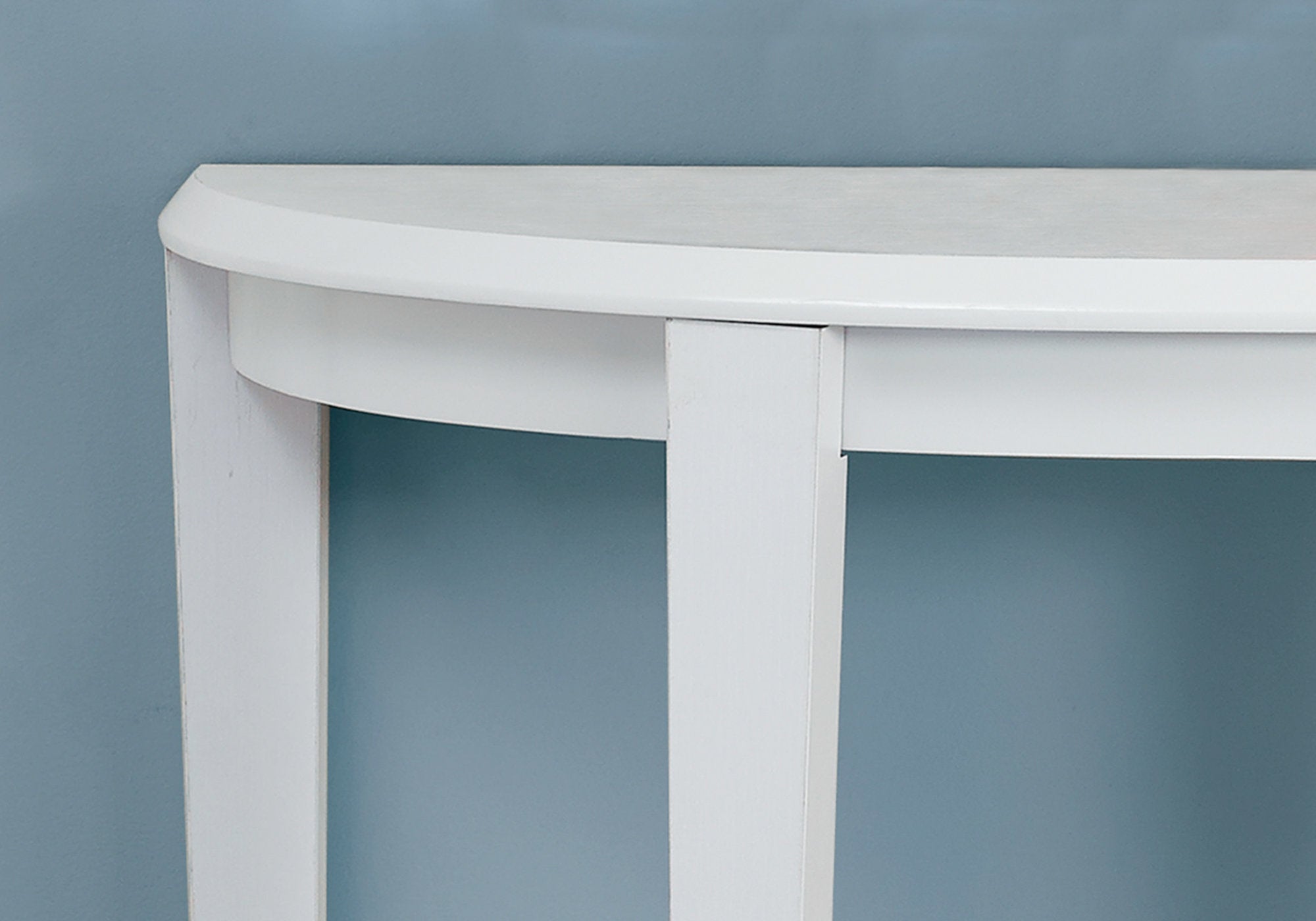 A stylish white finish accent table with a curved half-moon shape and tapered legs, perfect for enhancing living spaces.