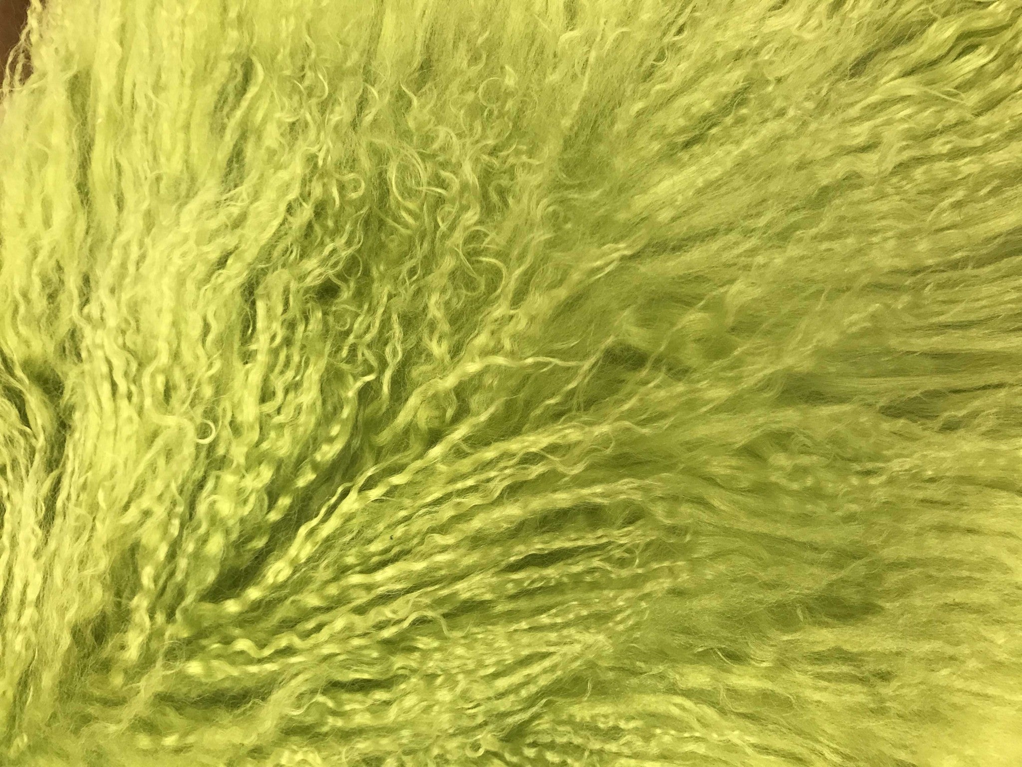 A vibrant 17-inch lime green pillow made from genuine Tibetan lamb fur with a soft microsuede backing, perfect for home decor.