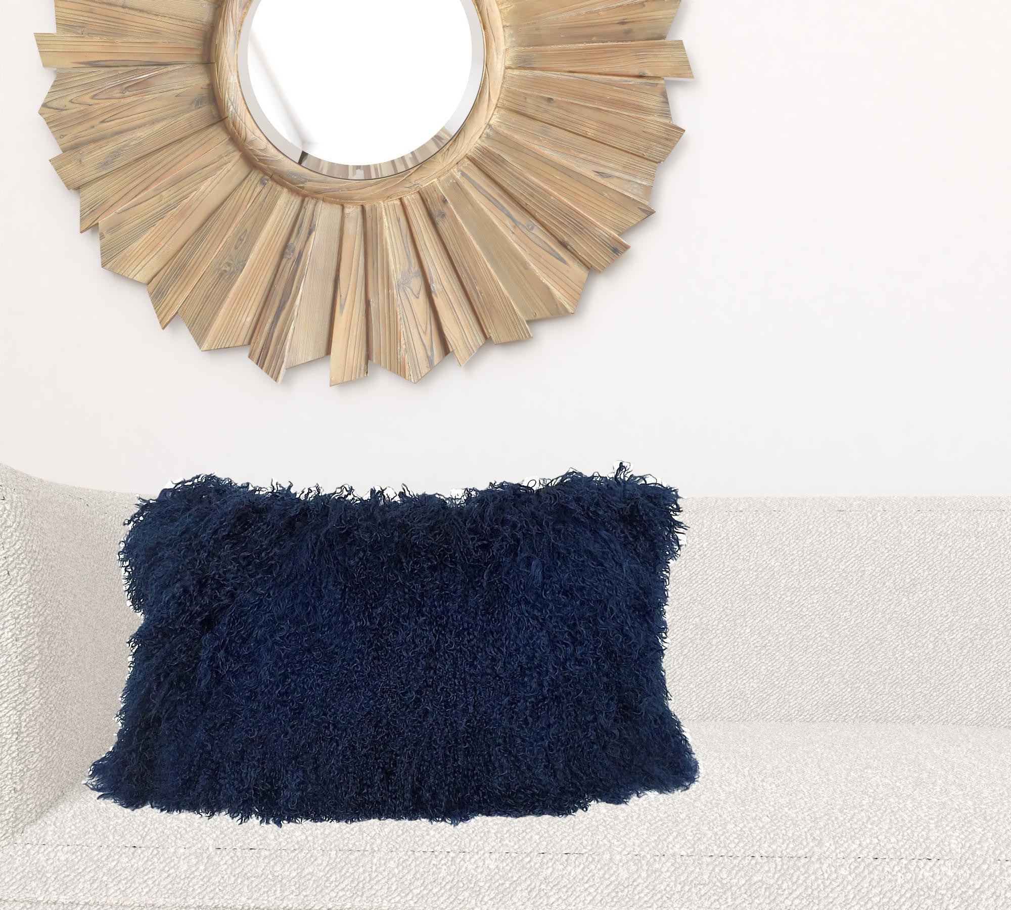 A luxurious 17-inch navy blue genuine Tibetan lamb fur pillow with a soft microsuede backing, elegantly displayed on a sofa.