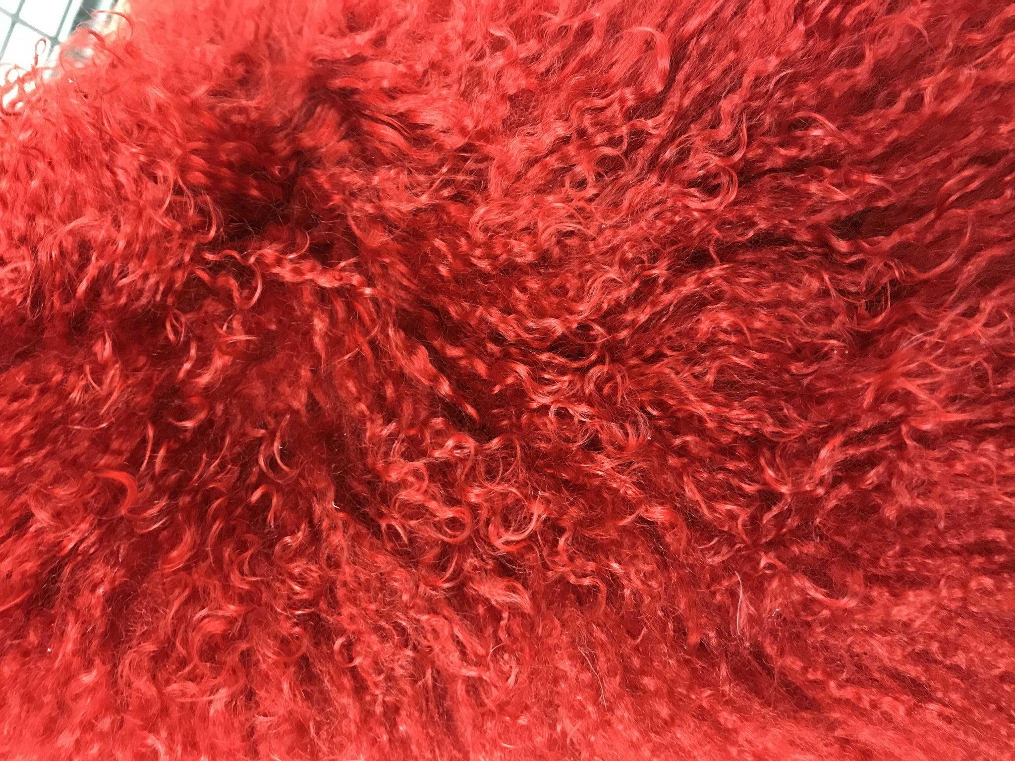 17-inch red genuine Tibetan lamb fur pillow with soft microsuede backing, showcasing luxurious texture and vibrant color.