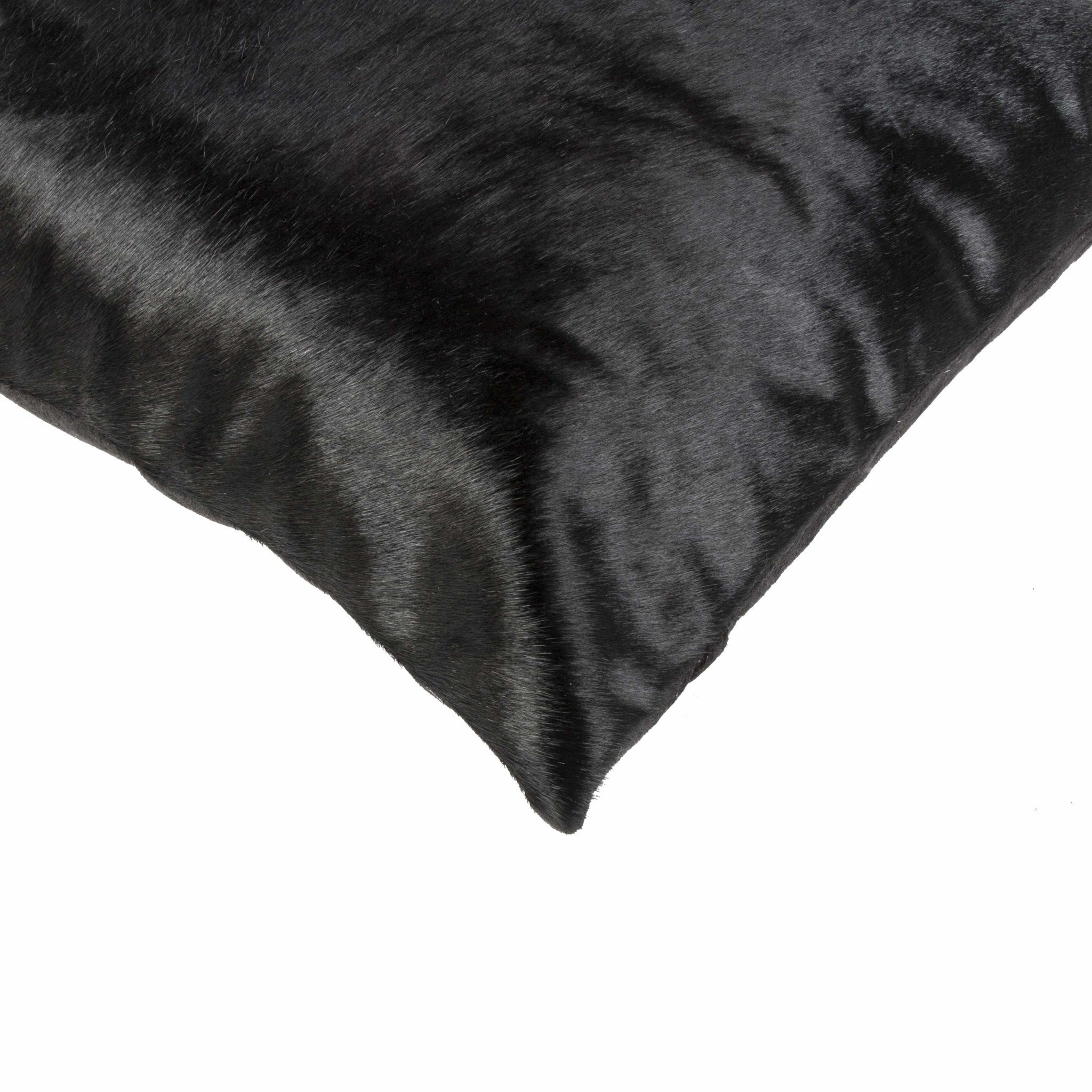 Luxurious 18x18 black cowhide pillow with unique mottling and soft microsuede backing, featuring a hidden zipper closure.