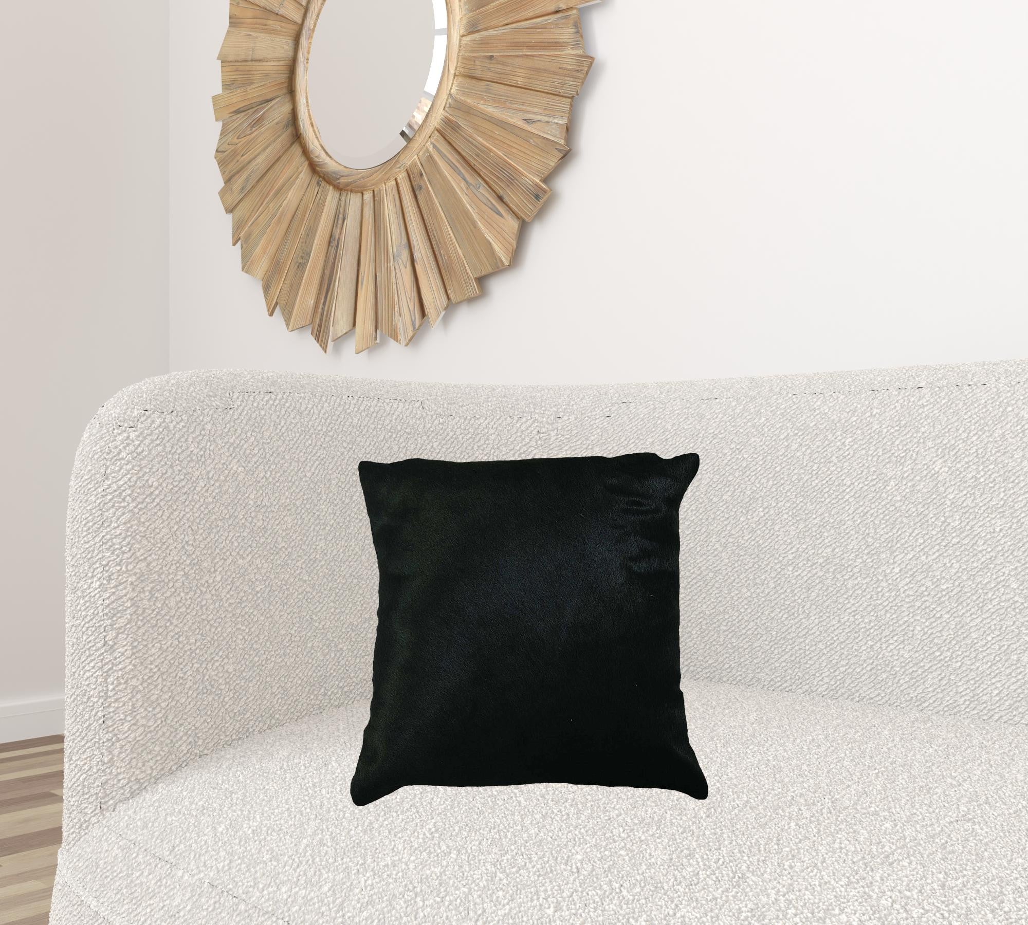 Luxurious 18x18 black cowhide pillow with unique mottling and soft microsuede backing, featuring a hidden zipper closure.