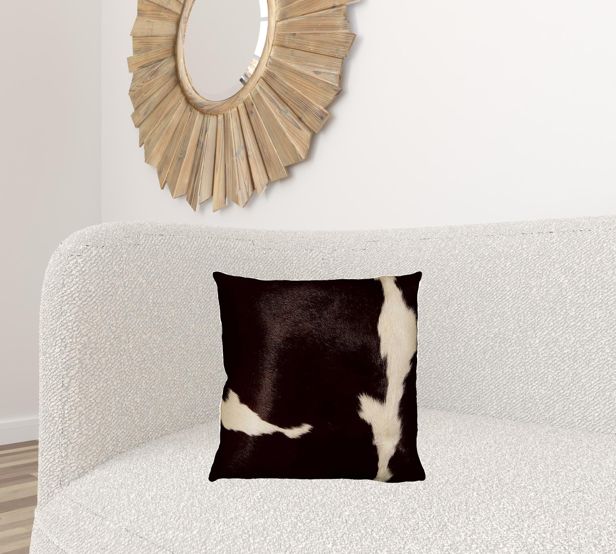 Luxurious 18x18 black cowhide pillow with unique mottling and soft microsuede backing, featuring a hidden zipper closure.