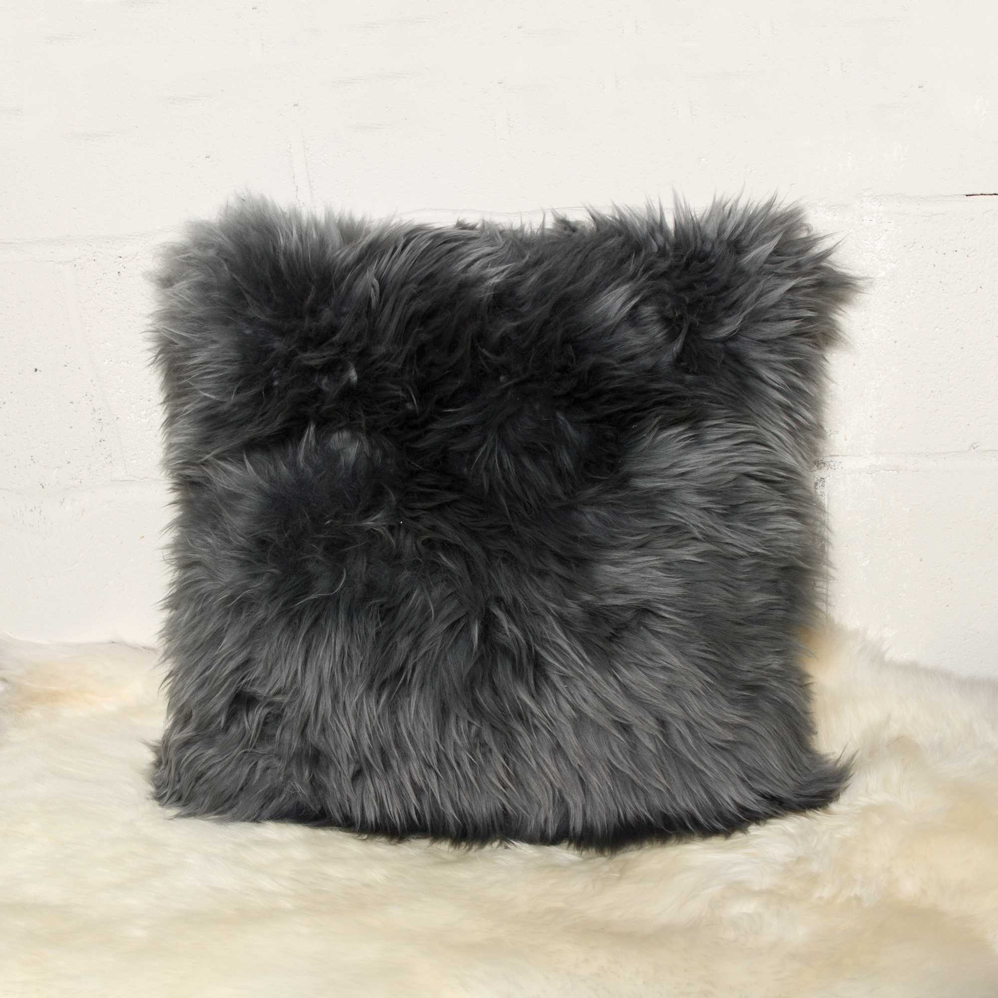 Two luxurious gray sheepskin pillows measuring 18x18 inches with soft microsuede backing, showcasing plush texture and hidden zipper closure.