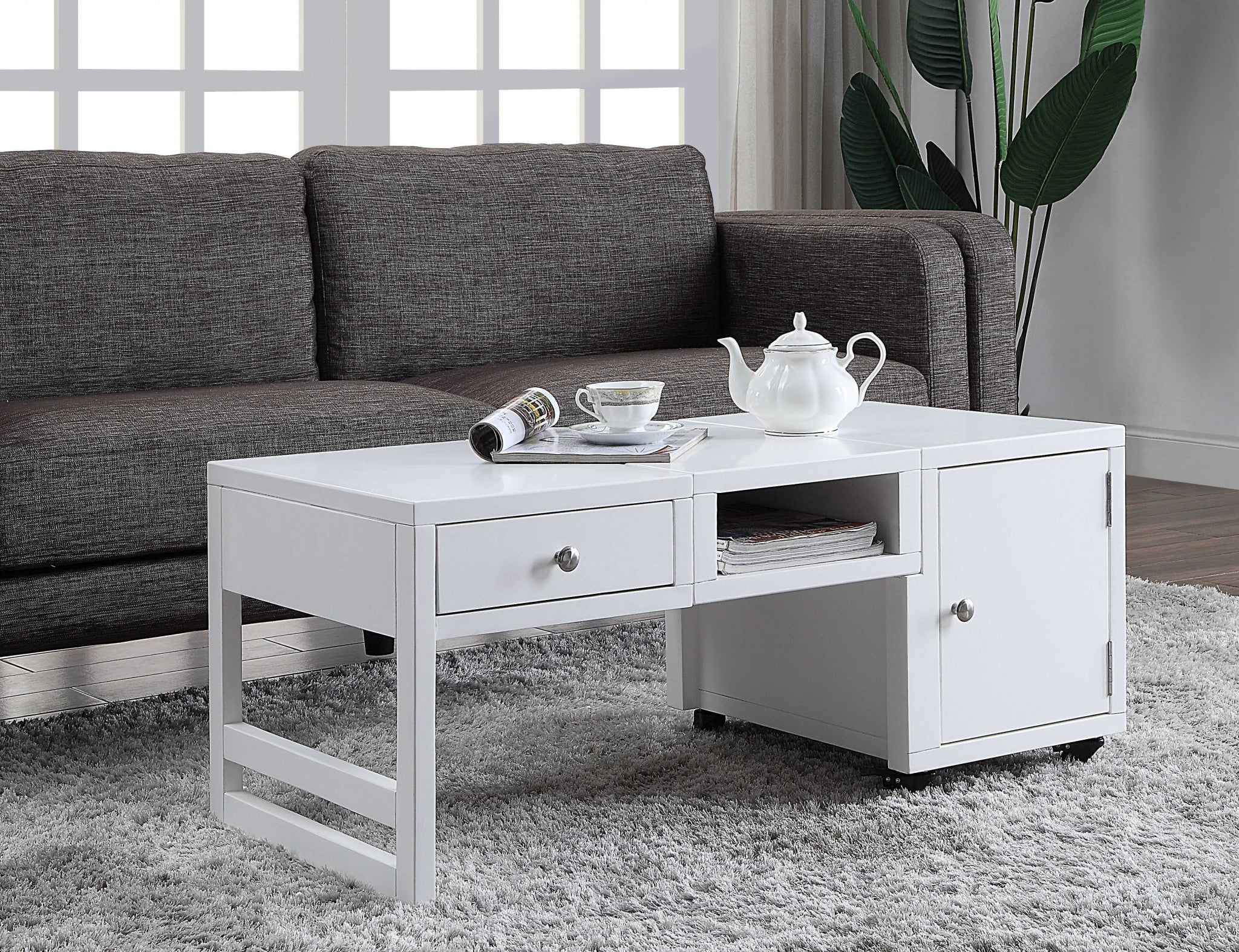 A stylish black wood veneer coffee table with metal legs and caster wheels, featuring a cabinet, open shelf, and drawer, perfect for modern living rooms.